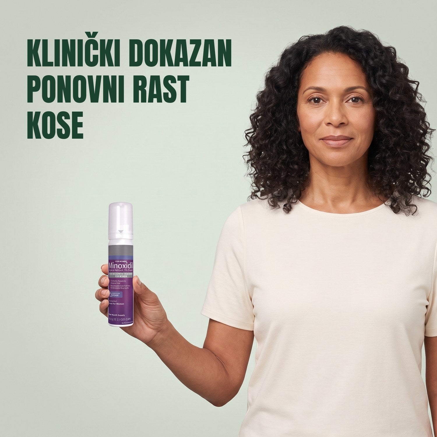 Žena drži limenku Kirkland Signature Minoksidil 5% pjena za žene na zelenoj pozadini