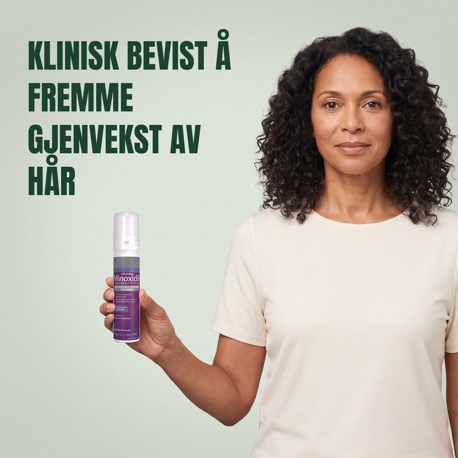 Kvinne holder en boks med Kirkland Signature Minoxidil 5% skum for kvinner mot en grønn bakgrunn