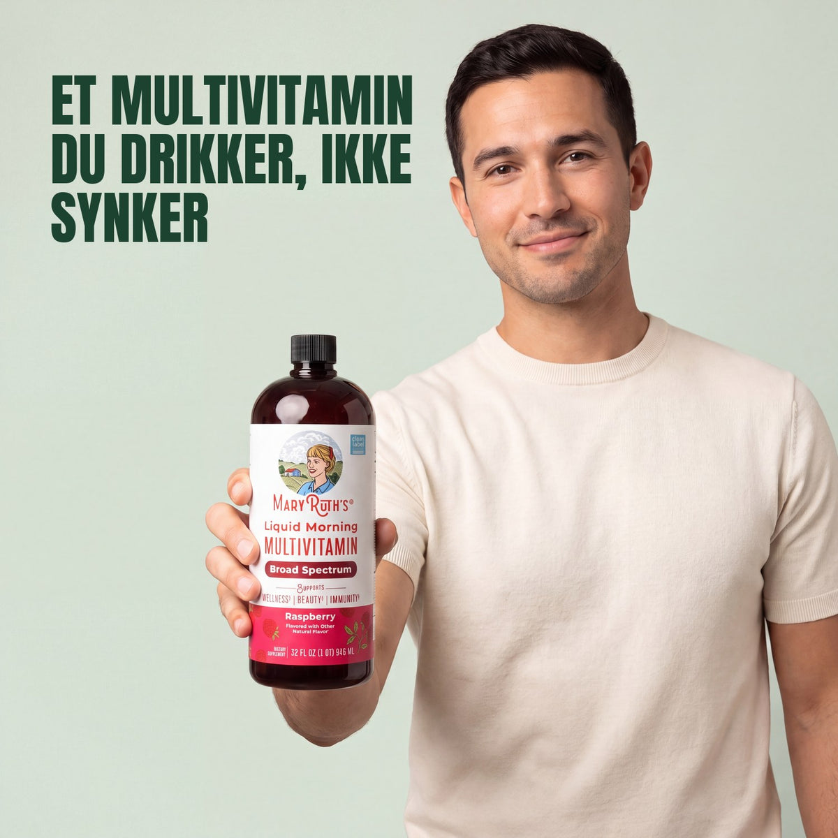 Man holding a MaryRuth Organics Liquid Morning Multivitamin raspberry bottle against a green background