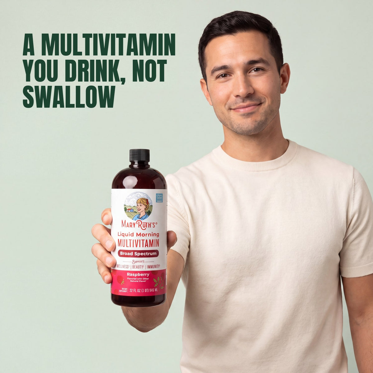 Man holding a MaryRuth Organics Liquid Morning Multivitamin raspberry bottle against a green background