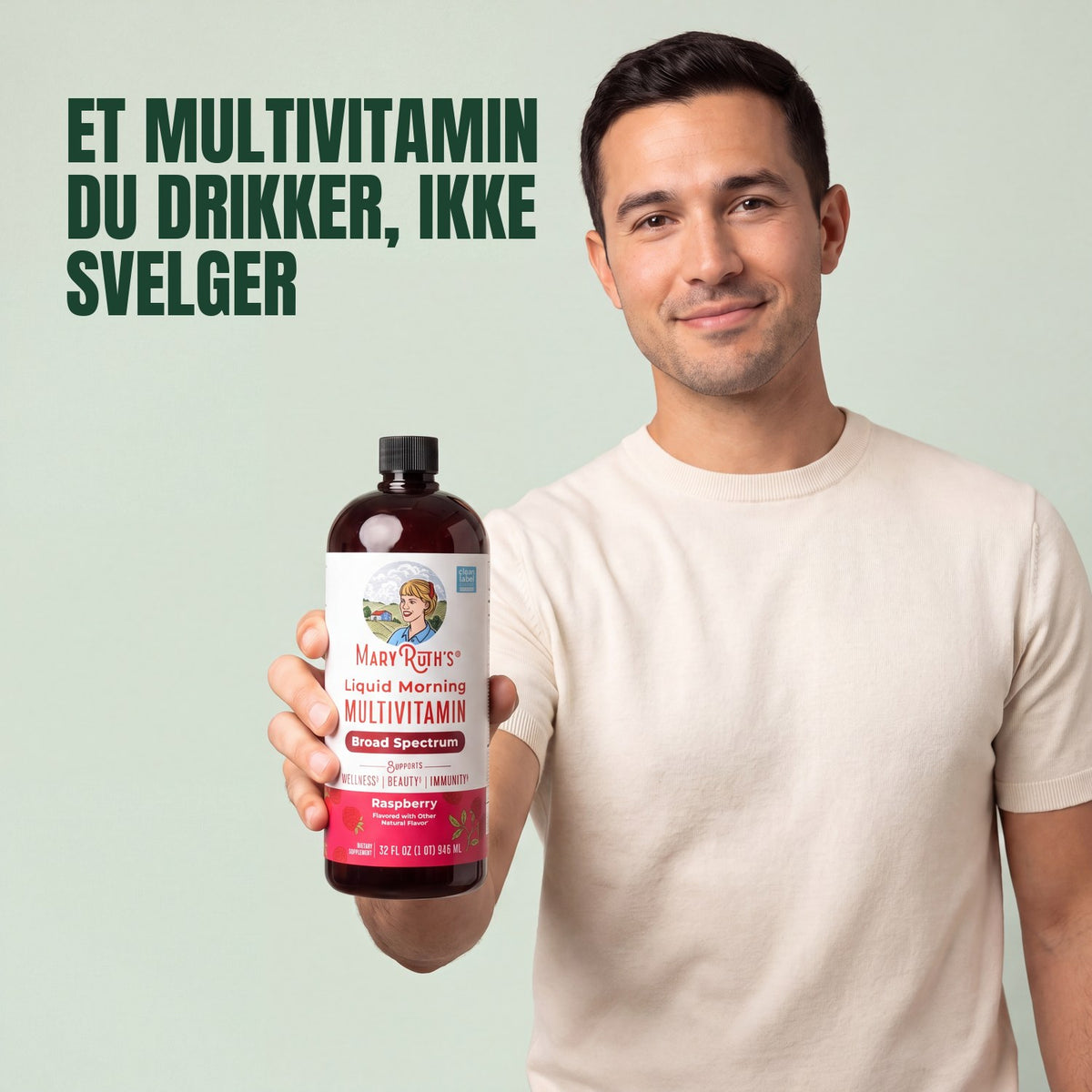 Man holding a MaryRuth Organics Liquid Morning Multivitamin raspberry bottle against a green background
