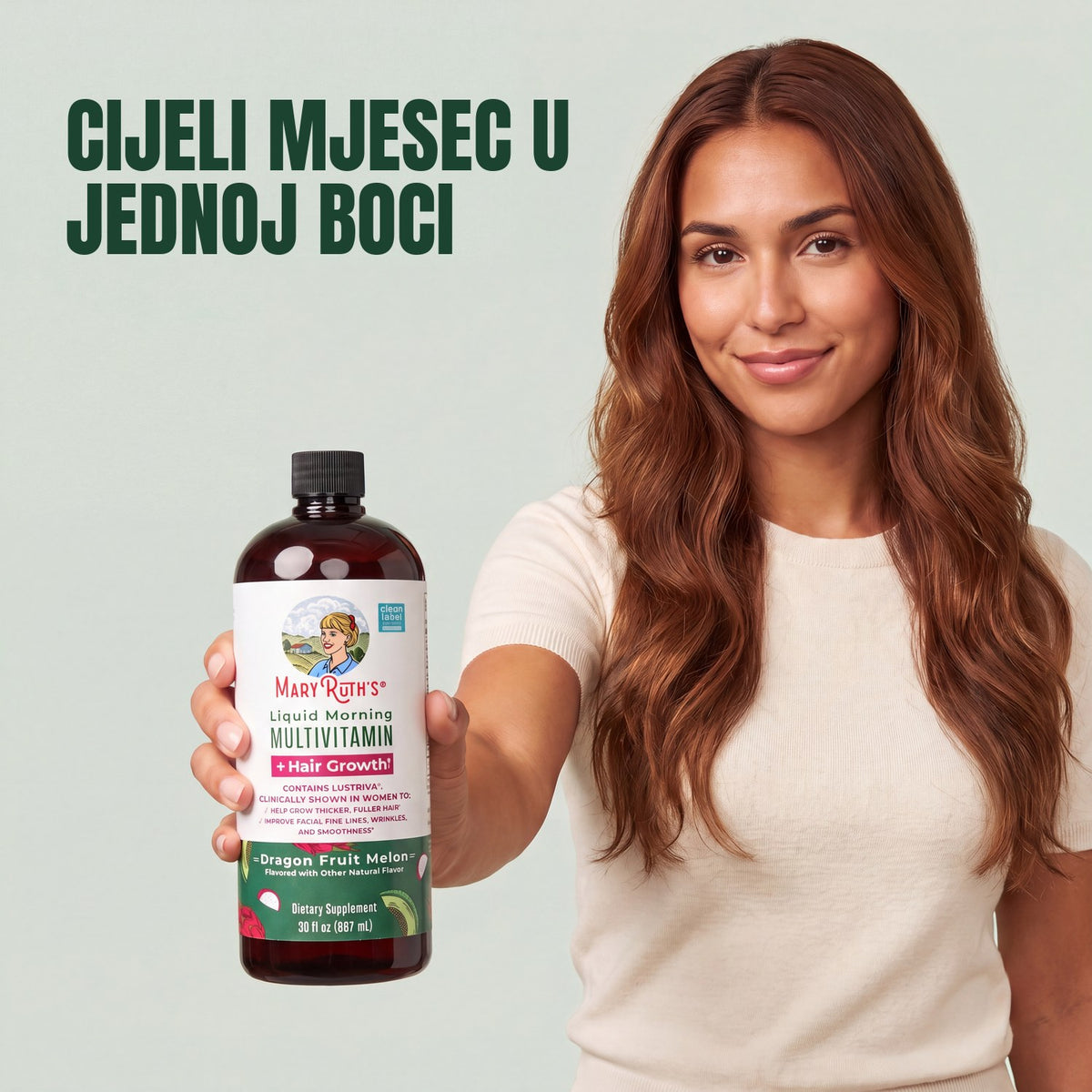 Woman holding a MaryRuth Organics Liquid Morning Multivitamin + Hair Growth dragon fruit melon bottle against a green background