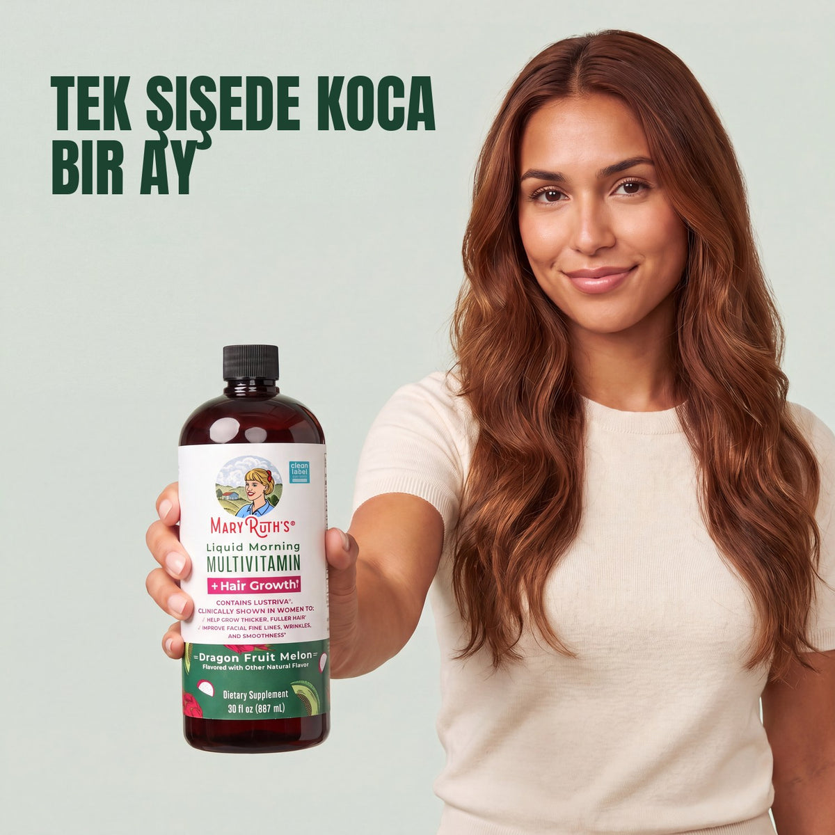 Woman holding a MaryRuth Organics Liquid Morning Multivitamin + Hair Growth dragon fruit melon bottle against a green background