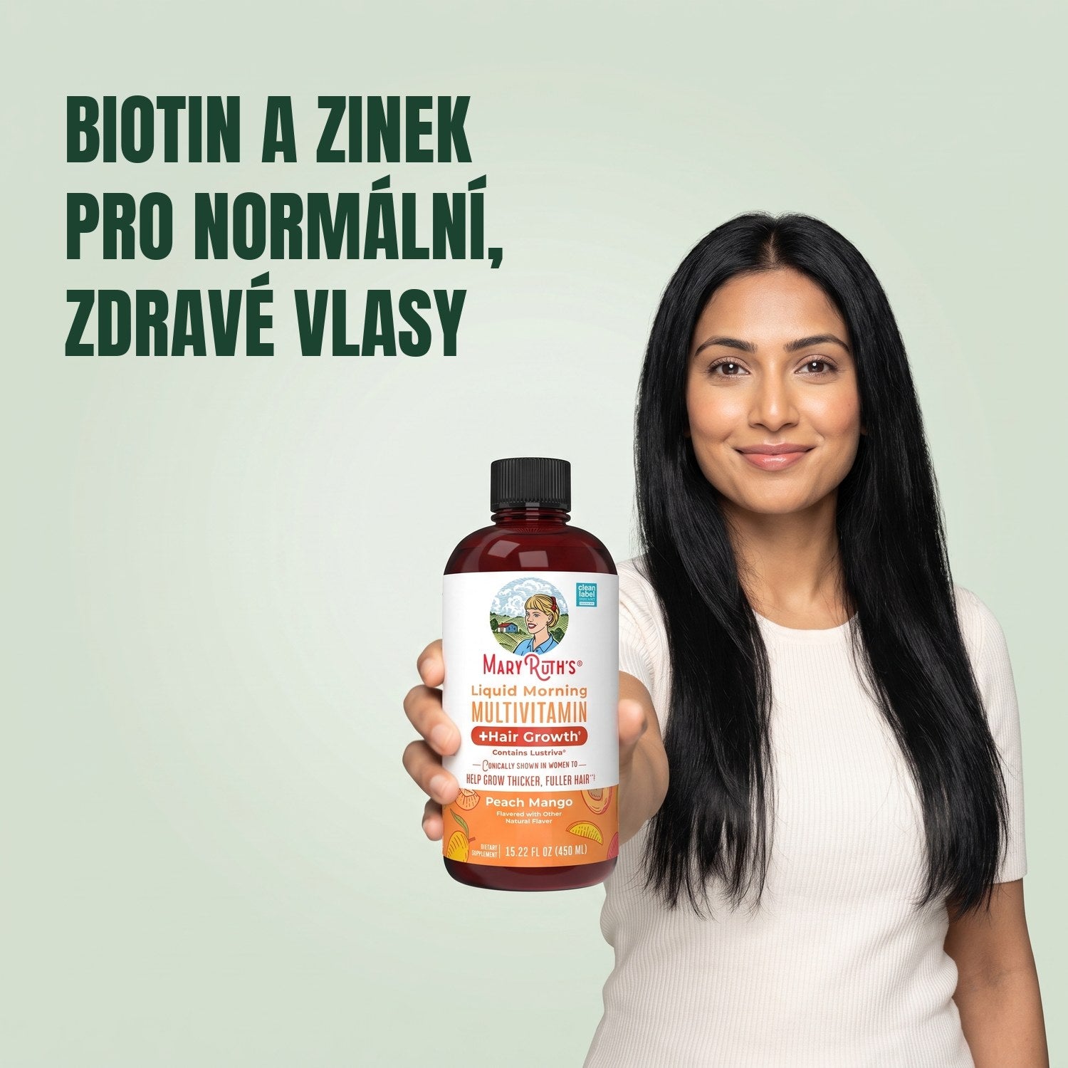 Žena drží lahvičku MaryRuth Organics Liquid Morning Multivitamin na zeleném pozadí