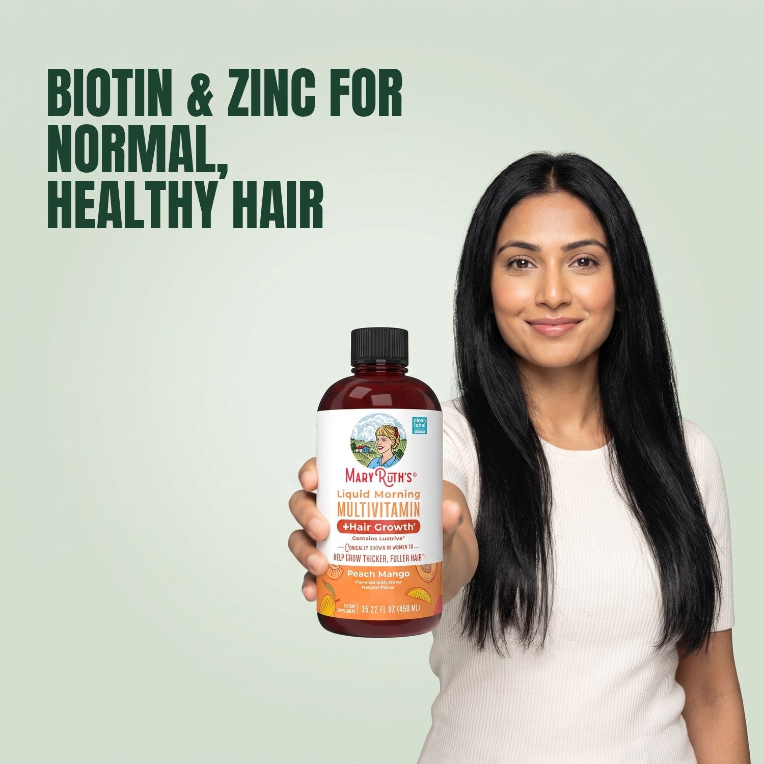 Woman holding a MaryRuth Organics Liquid Morning Multivitamin bottle against a green background