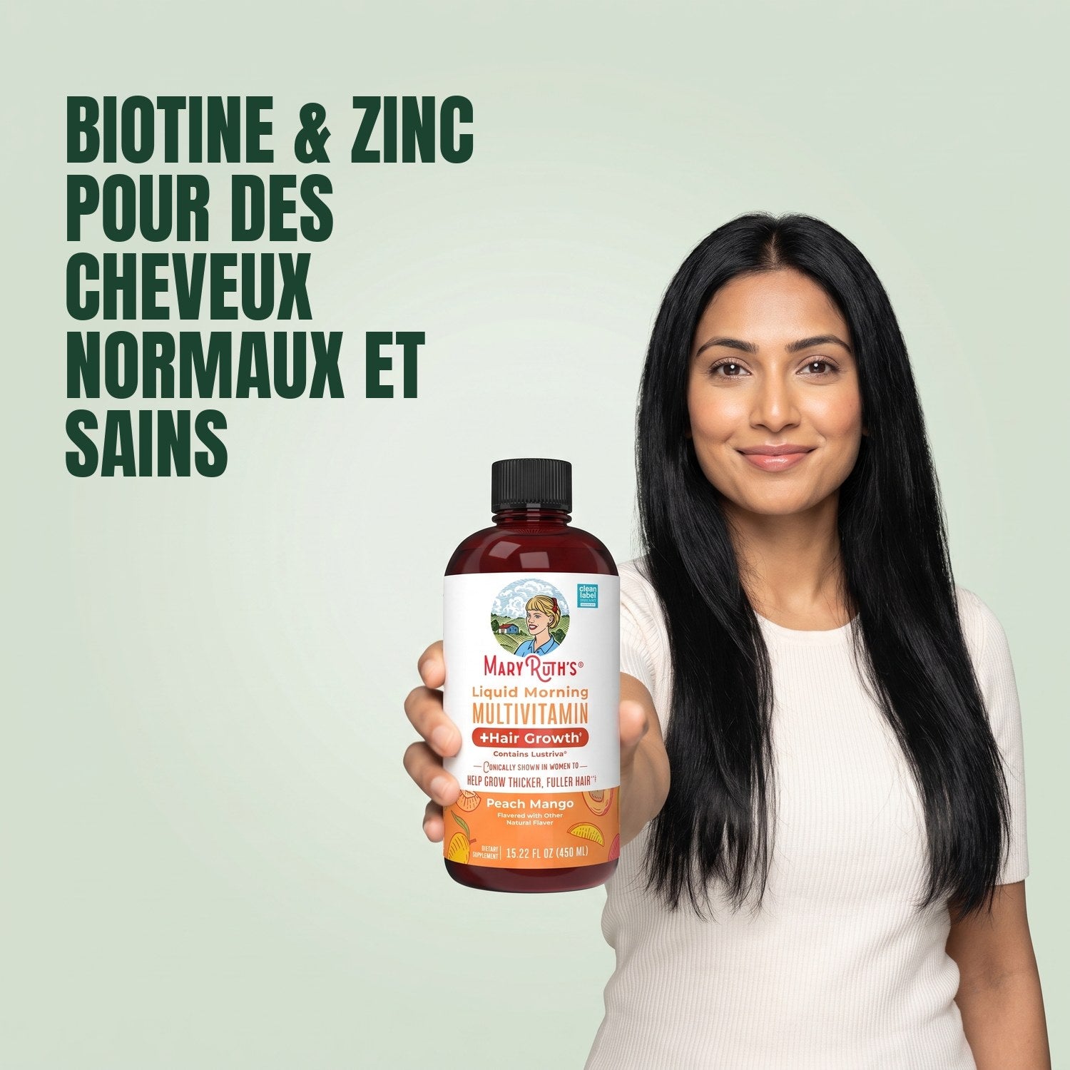 Woman holding a MaryRuth Organics Liquid Morning Multivitamin bottle against a green background
