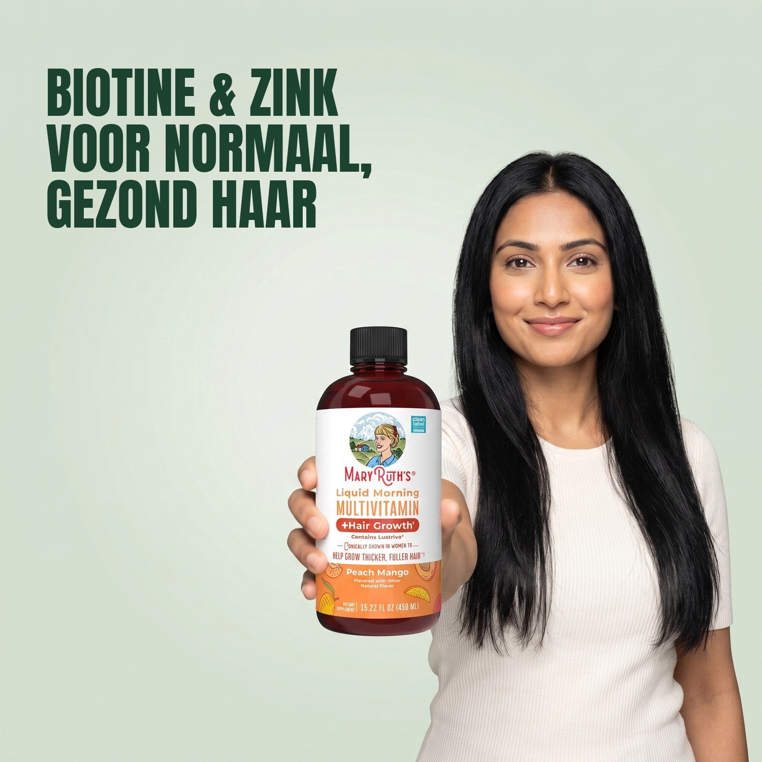 Woman holding a MaryRuth Organics Liquid Morning Multivitamin bottle against a green background