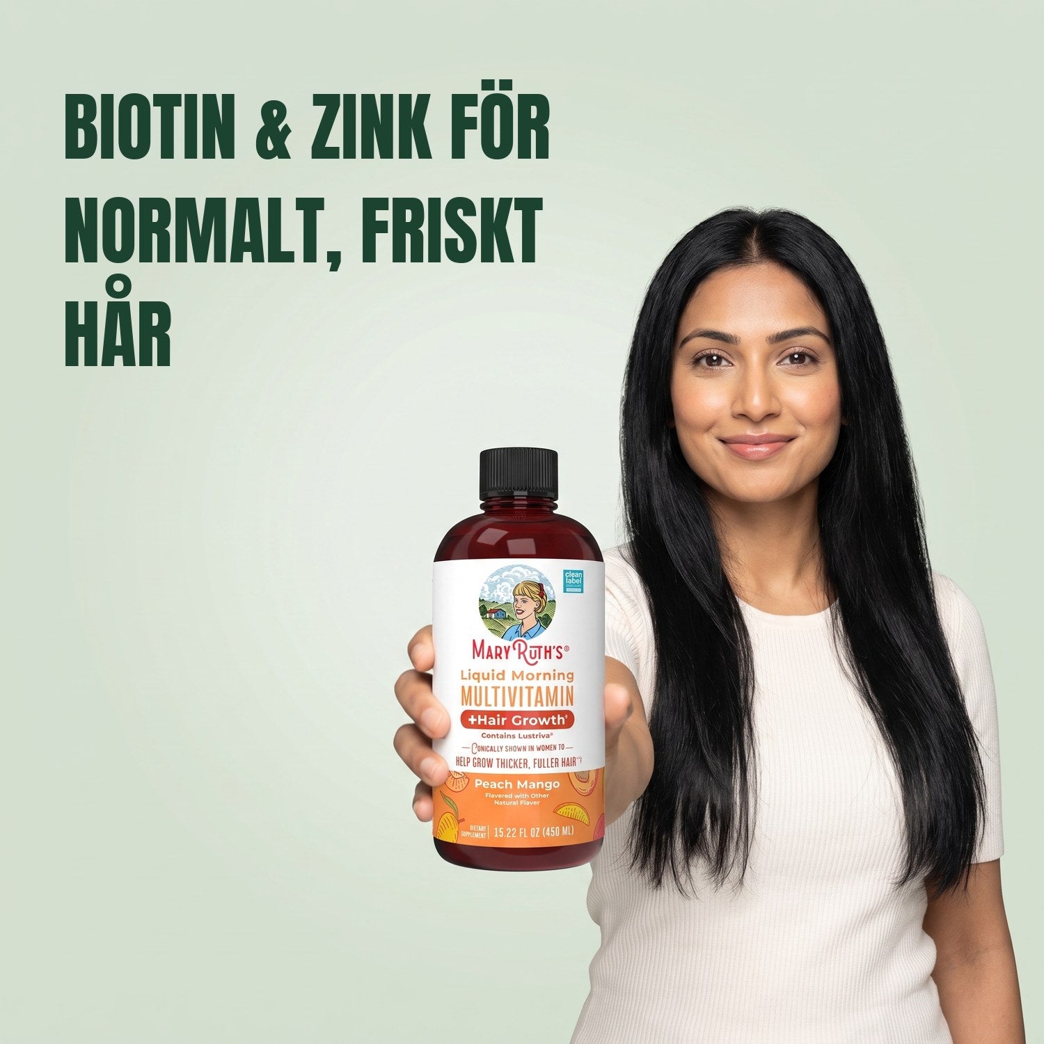 Kvinna håller en flaska MaryRuth Organics Liquid Morning Multivitamin mot en grön bakgrund