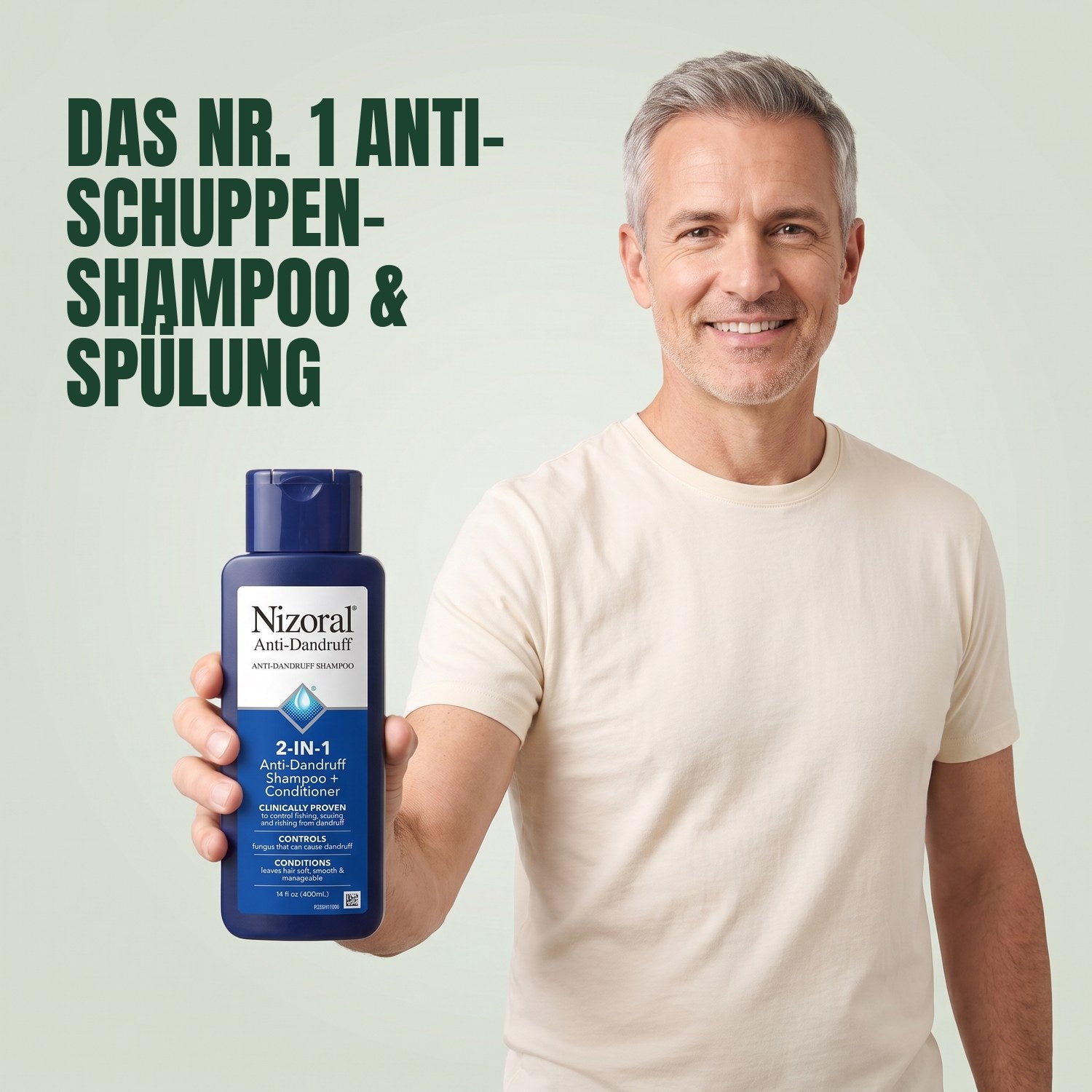 Man holding a Nizoral 2-in-1 anti-dandruff shampoo and conditioner bottle against a green background