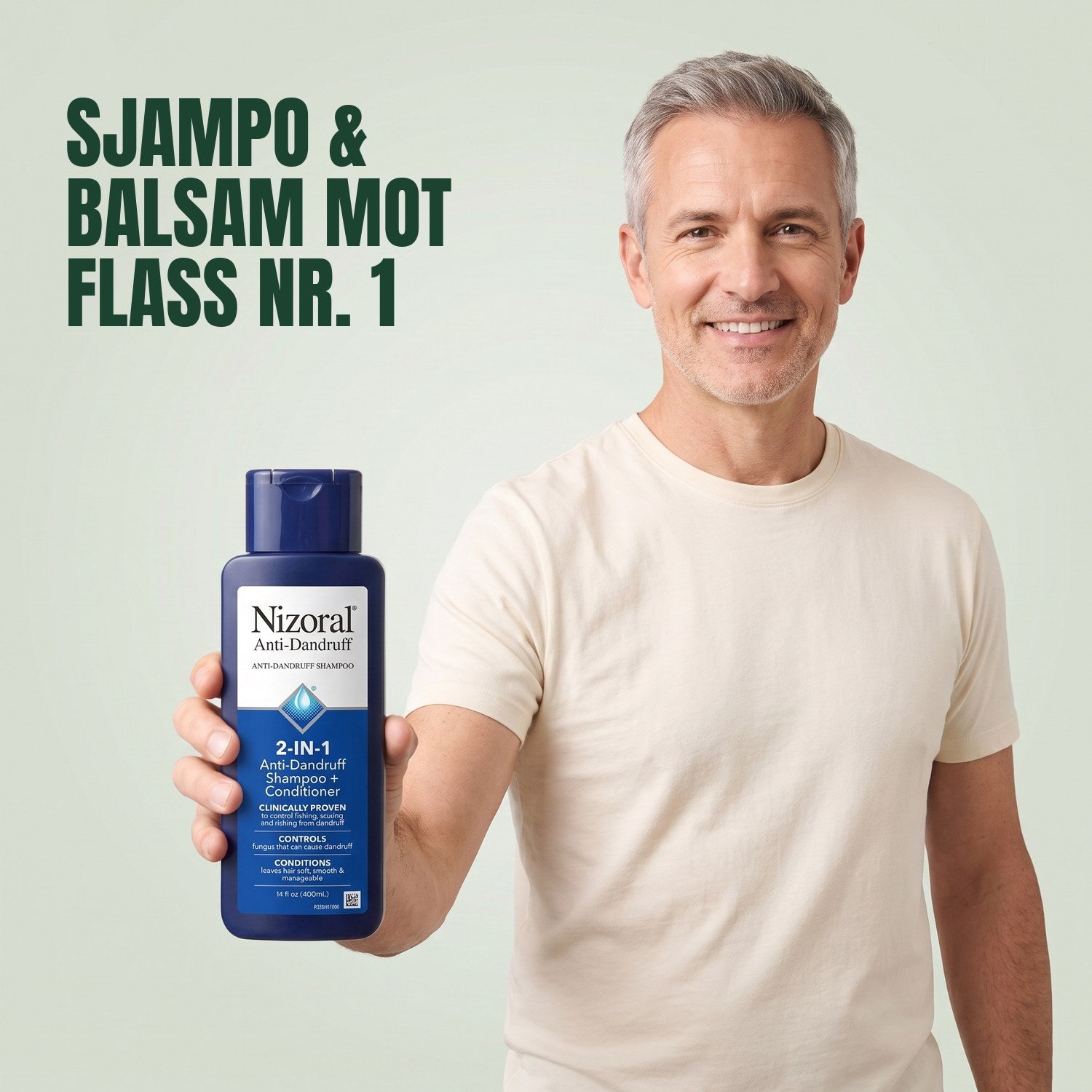 Mann som holder en flaske Nizoral 2-i-1 anti-flass sjampo og balsam mot en grønn bakgrunn