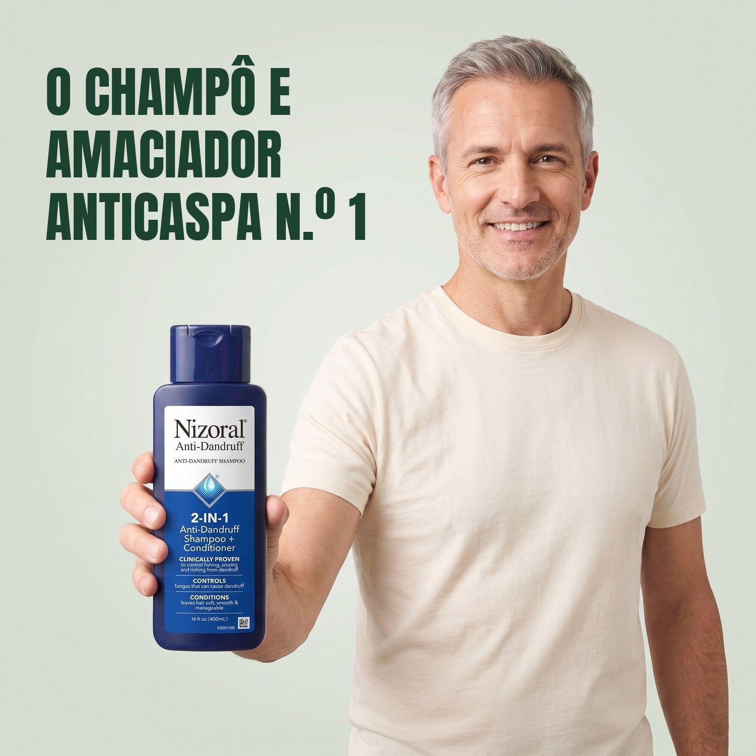 Homem a segurar um frasco de champô e amaciador Nizoral 2 em 1 anticaspa sobre fundo verde