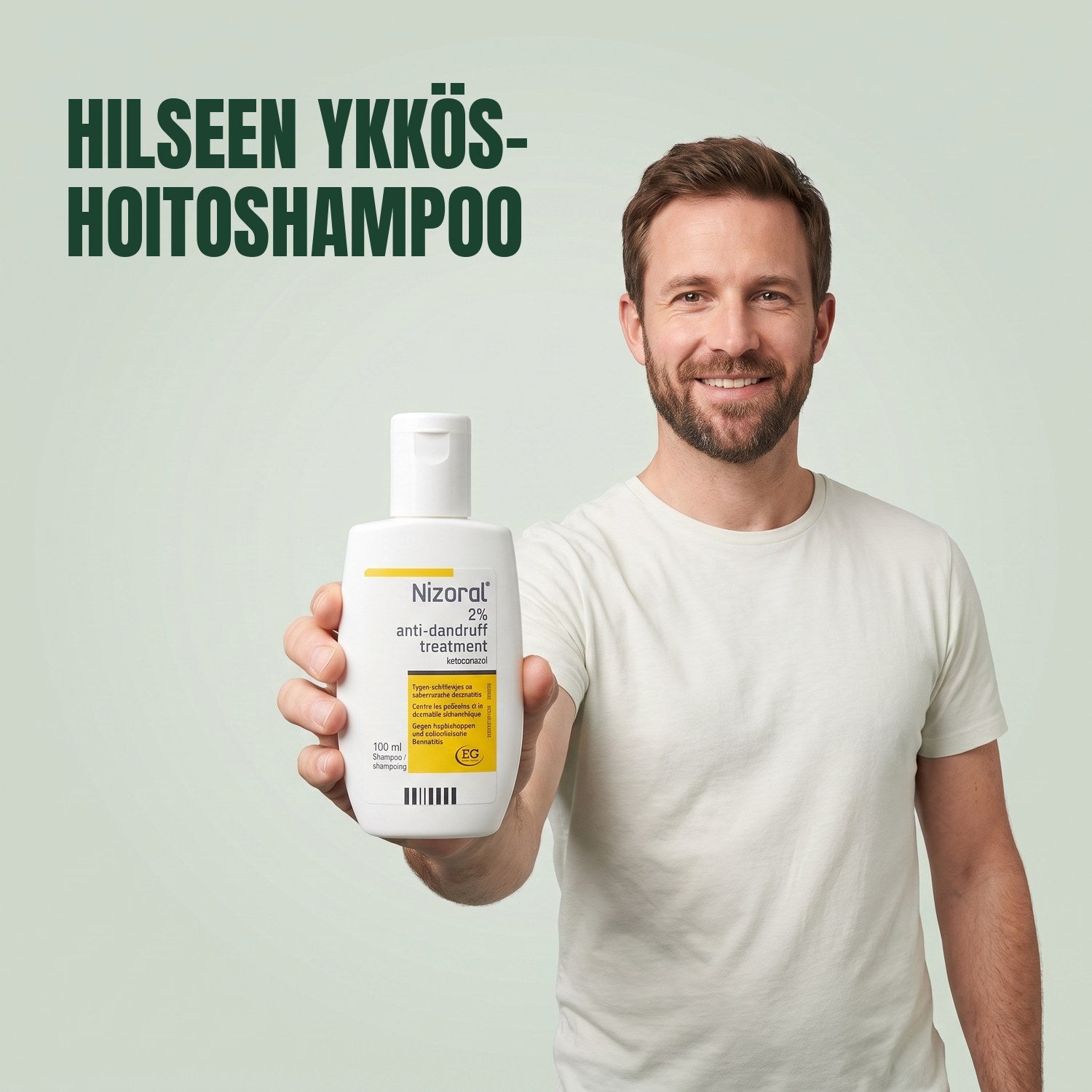 Mies pitelee Nizoral-hilseen hoitoshampoopulloa 2% 100 ml vihreää taustaa vasten