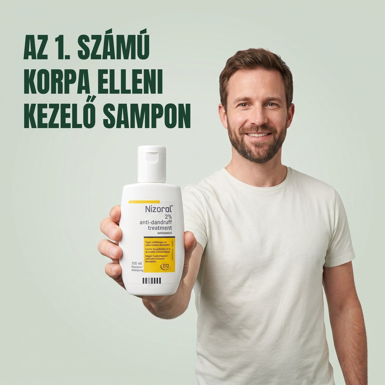 Férfi a Nizoral korpásodás elleni kezelő sampon 2%, 100 ml-es flakonját tartja zöld háttér előtt