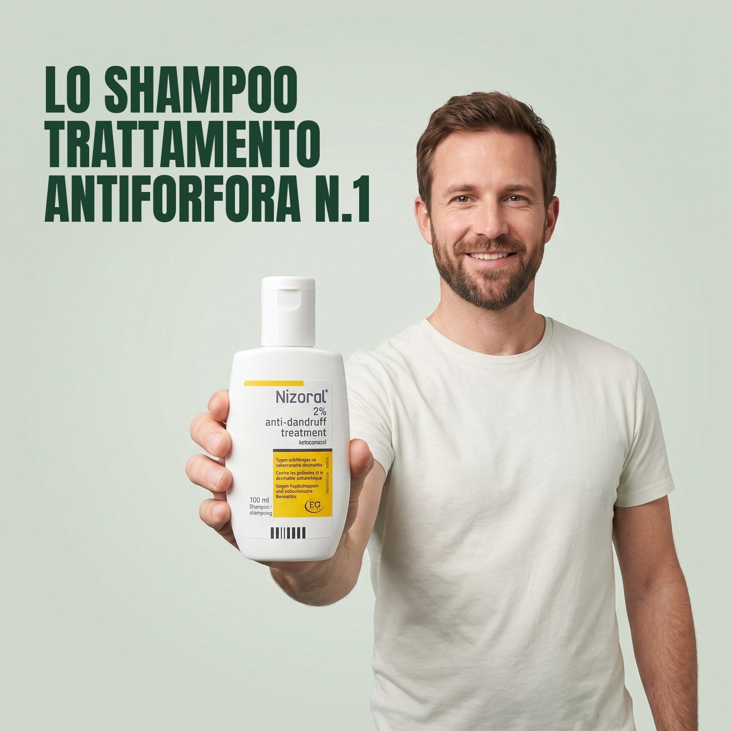Man holding a Nizoral anti-dandruff treatment shampoo 2% 100 ml bottle against a green background
