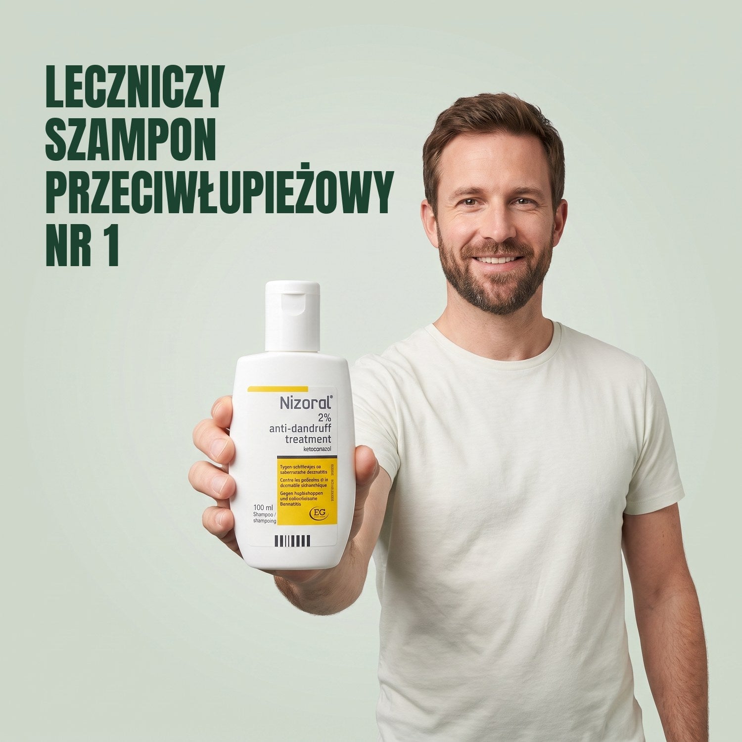 Man holding a Nizoral anti-dandruff treatment shampoo 2% 100 ml bottle against a green background