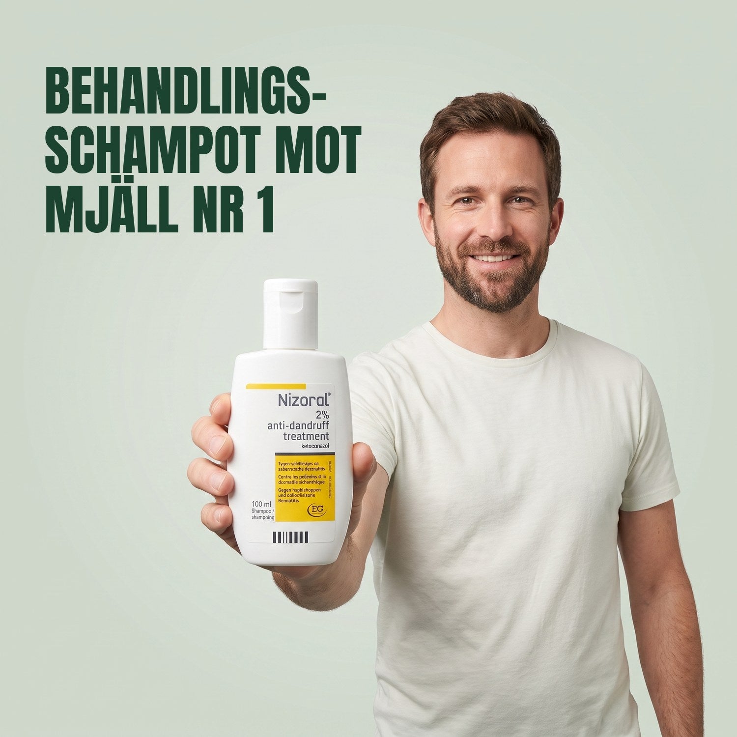 Man håller en flaska Nizoral behandlingsschampo mot mjäll 2%, 100 ml, mot en grön bakgrund
