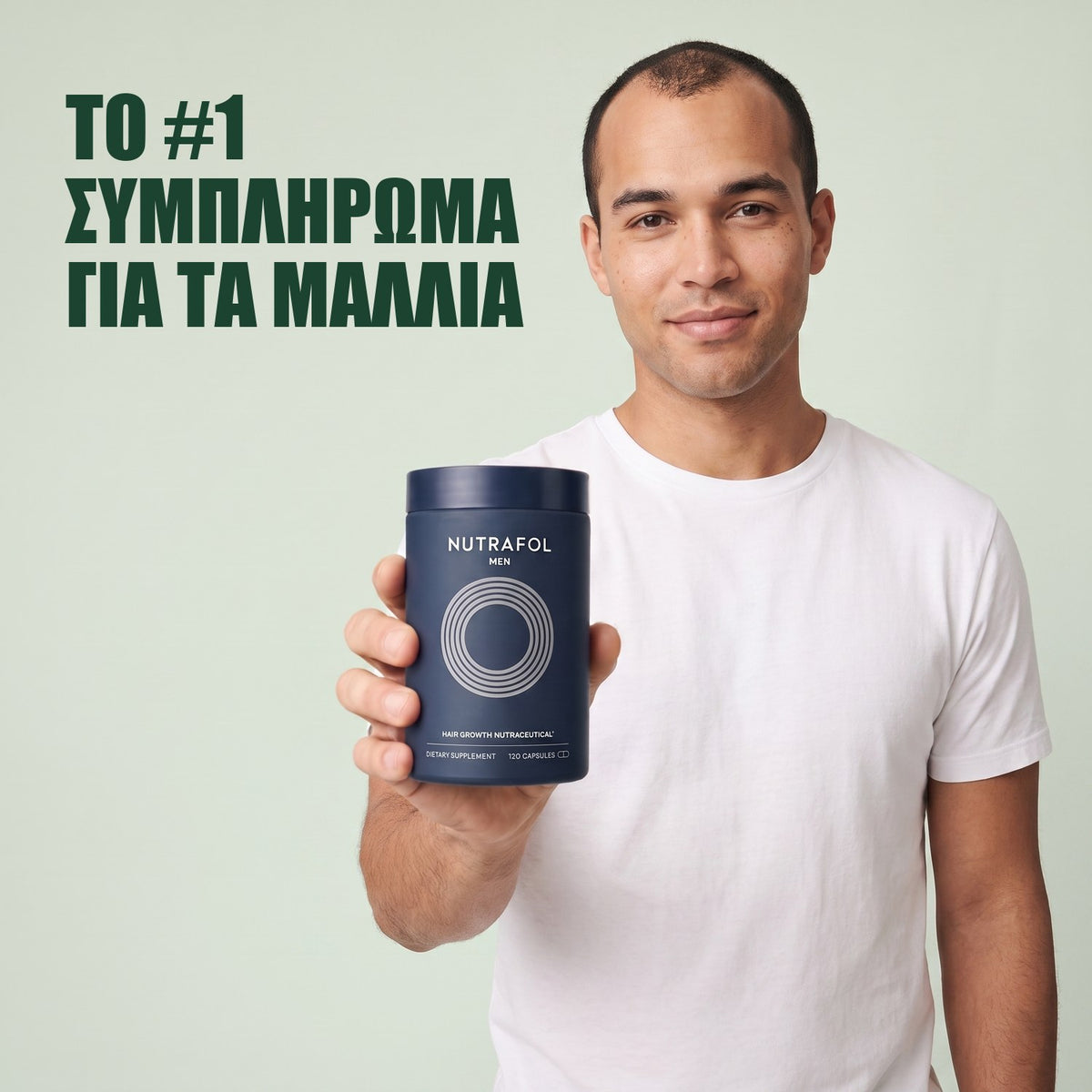Άντρας κρατά το κουτί συμπληρώματος διατροφής Nutrafol for Men σε πράσινο φόντο