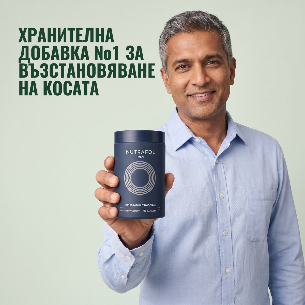 Мъж държи кутия хранителна добавка Nutrafol for Men на зелен фон