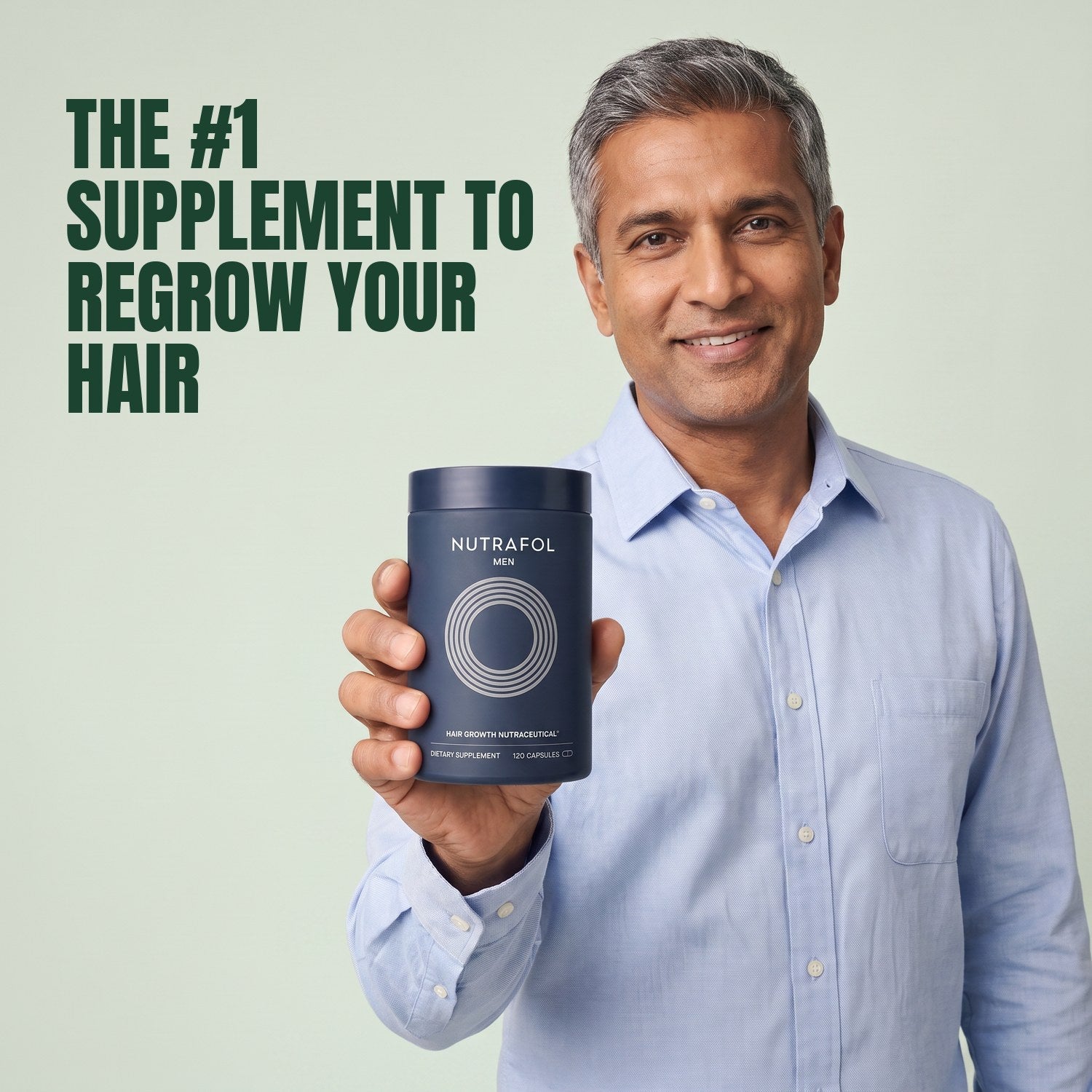 Man holding the Nutrafol for Men supplement box against a green background