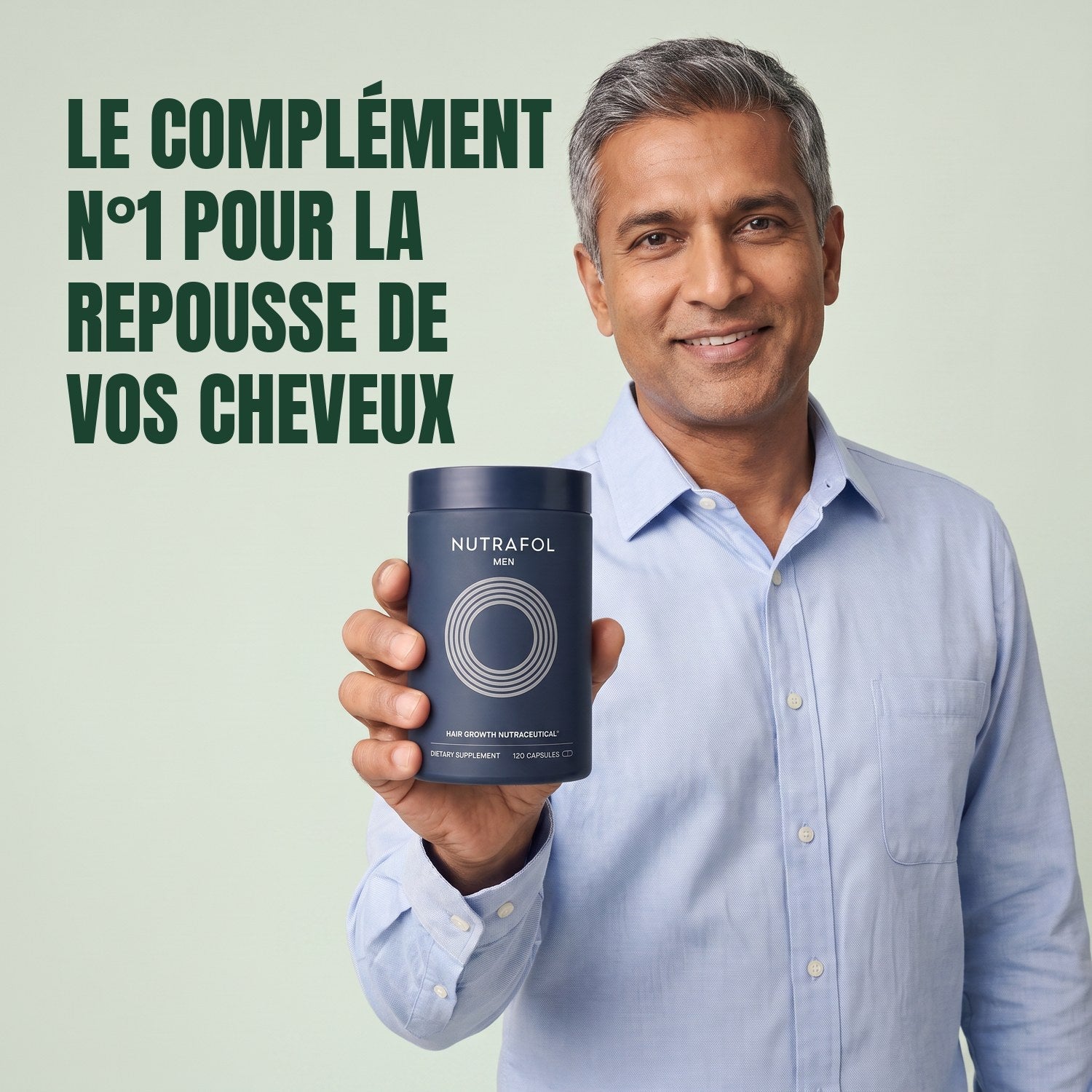 Man holding the Nutrafol for Men supplement box against a green background