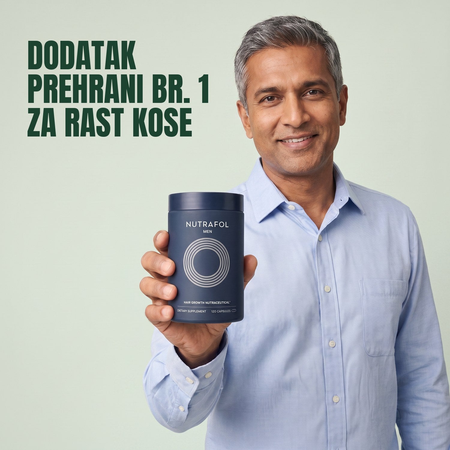 Muškarac drži kutiju dodatka prehrani Nutrafol for Men na zelenoj pozadini