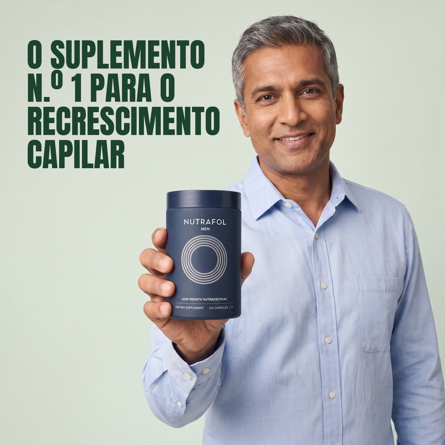Man holding the Nutrafol for Men supplement box against a green background