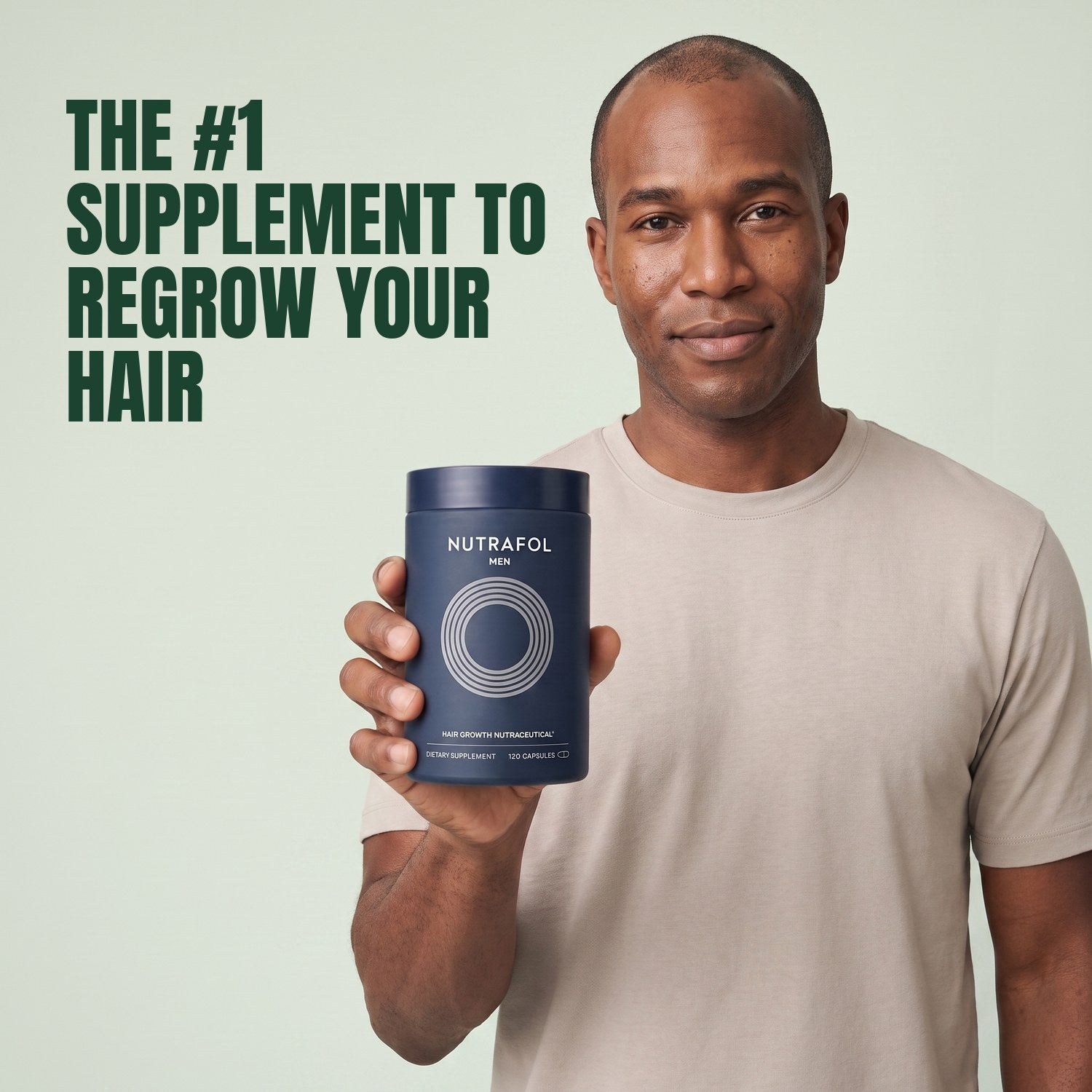 Man holding the Nutrafol for Men supplement box against a green background