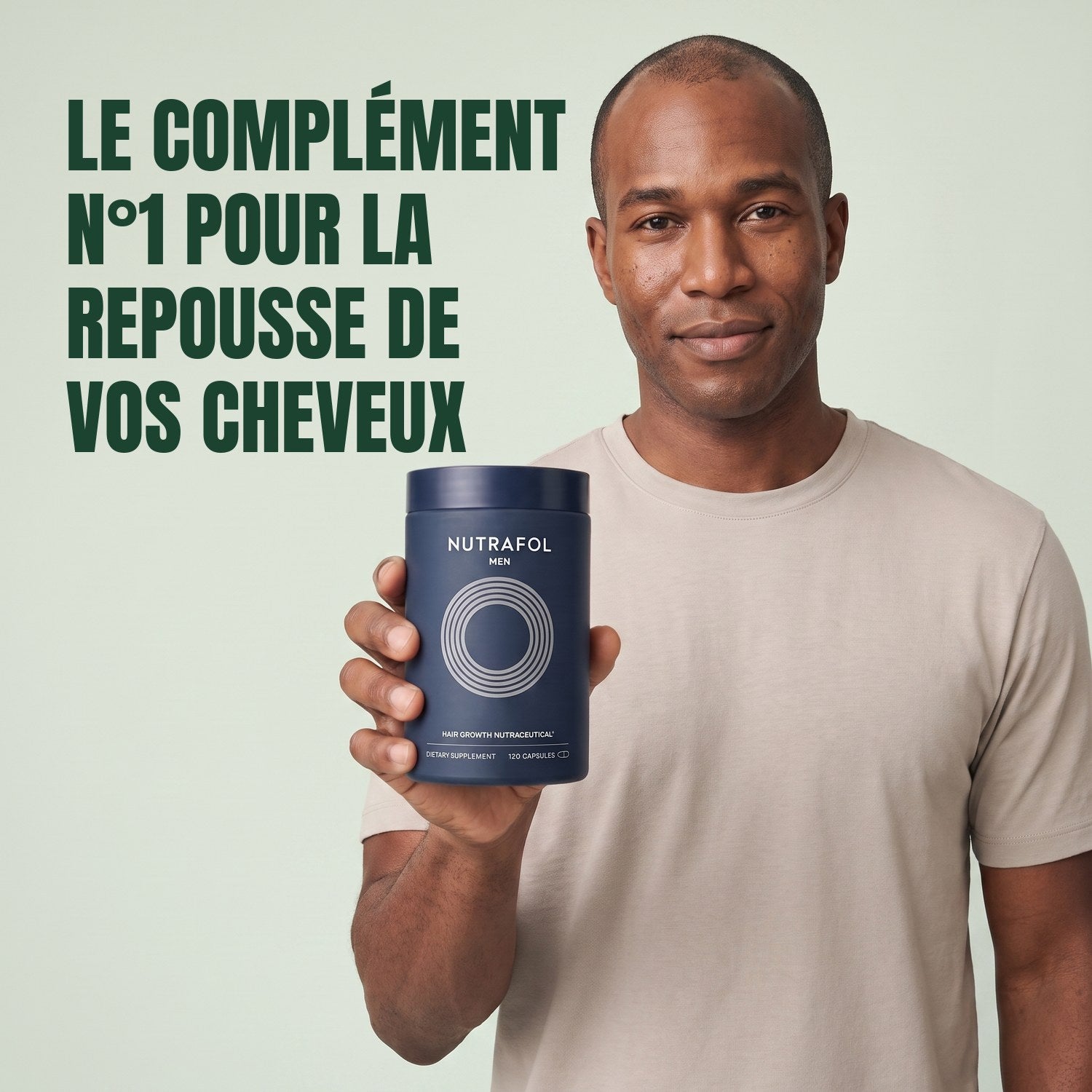 Man holding the Nutrafol for Men supplement box against a green background