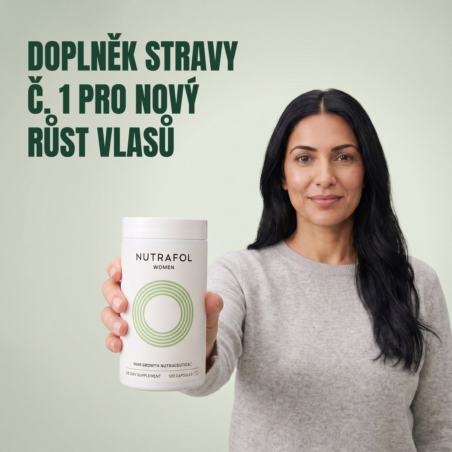 Žena drží krabičku doplňku stravy Nutrafol for Women 18-44 na zeleném pozadí