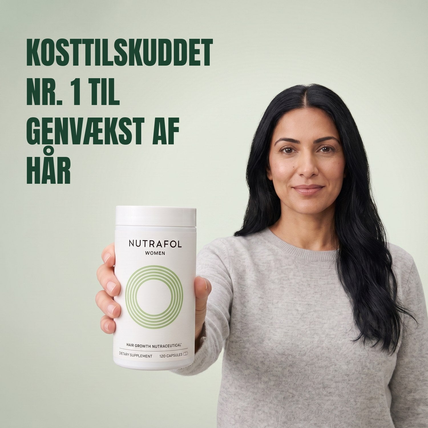 Woman holding the Nutrafol for Women 18-44 supplement box against a green background