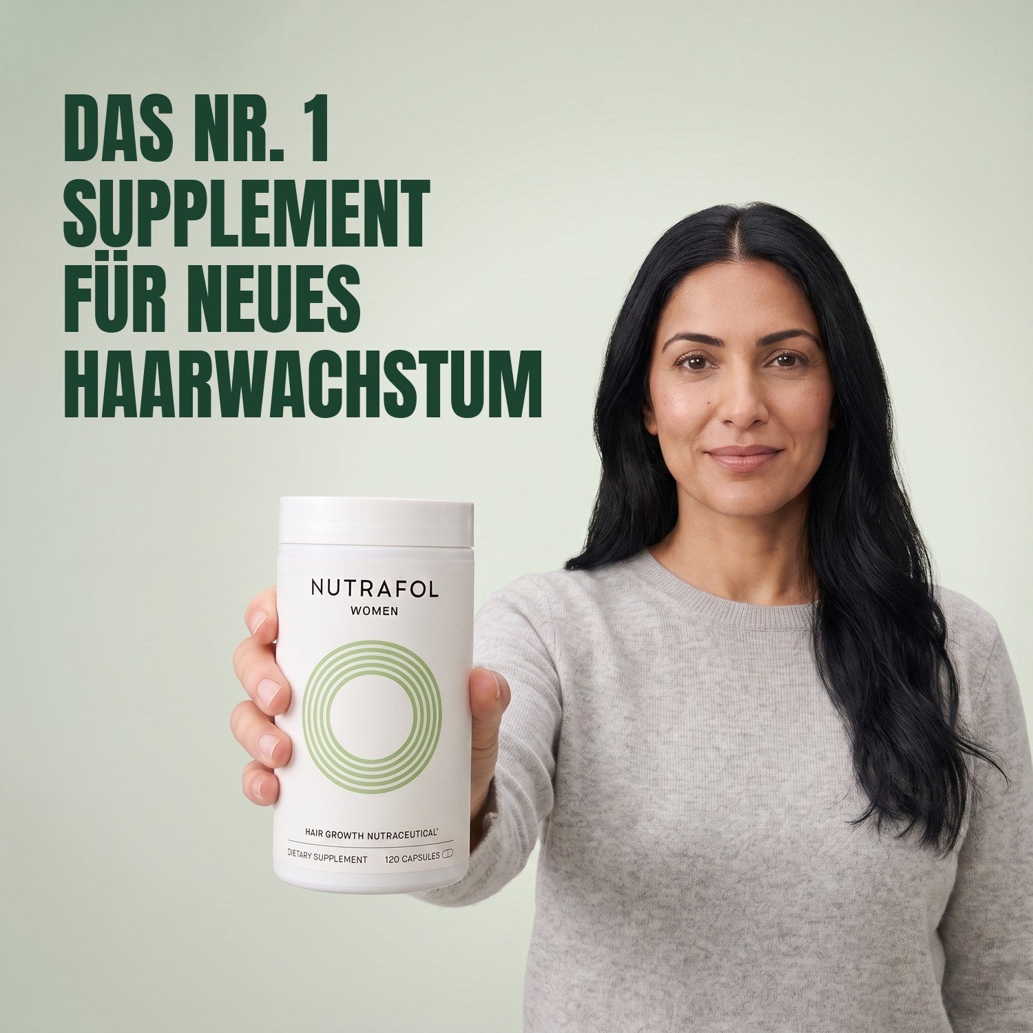 Woman holding the Nutrafol for Women 18-44 supplement box against a green background