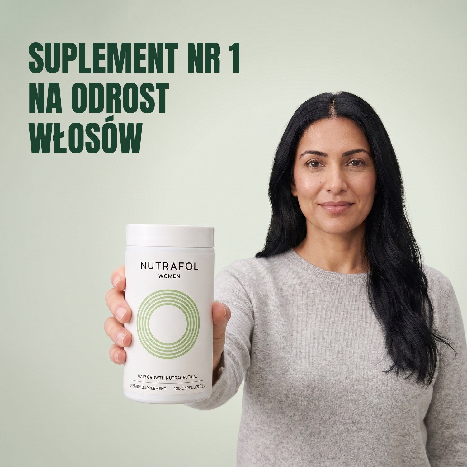 Kobieta trzyma pudełko suplementu Nutrafol for Women 18-44 na zielonym tle