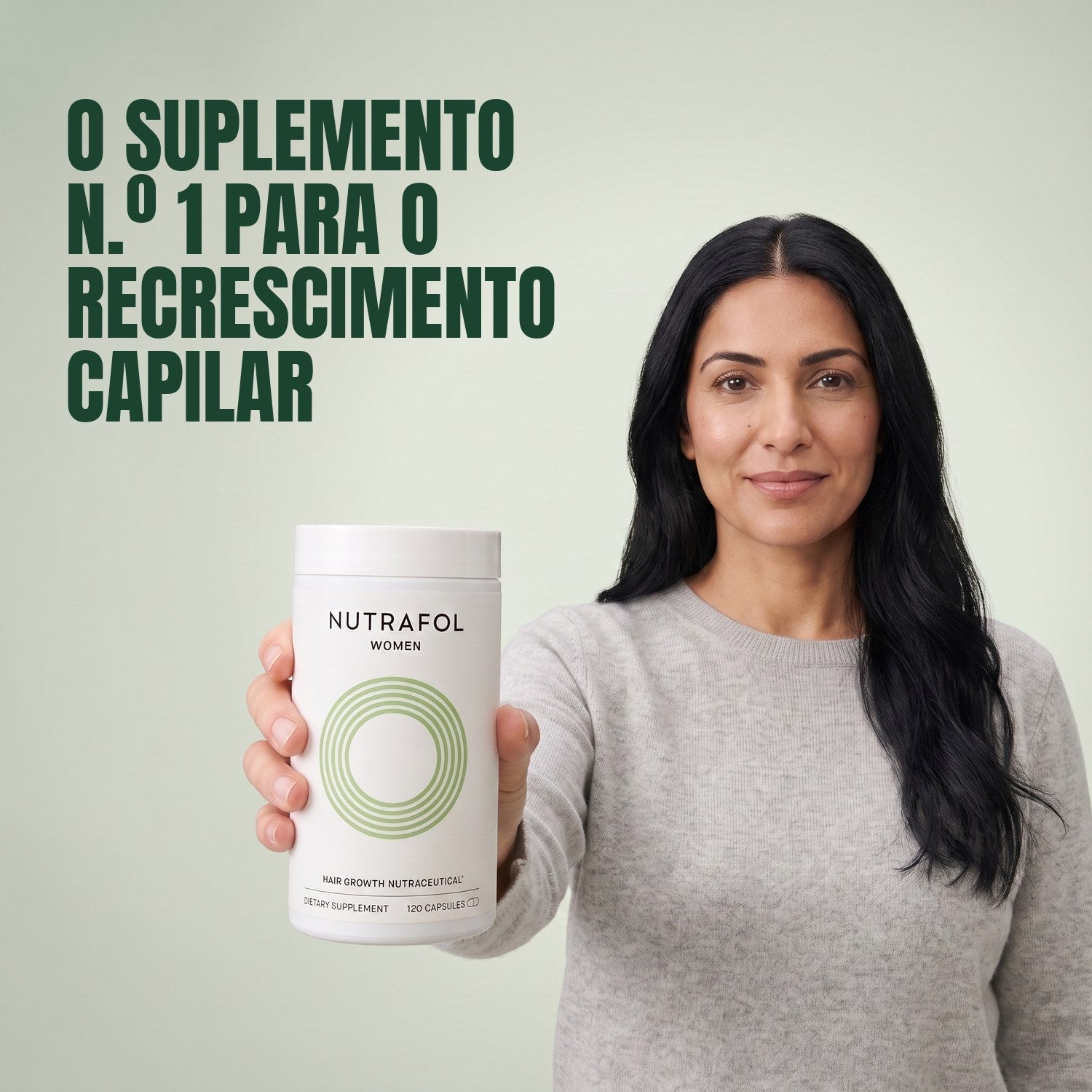 Woman holding the Nutrafol for Women 18-44 supplement box against a green background