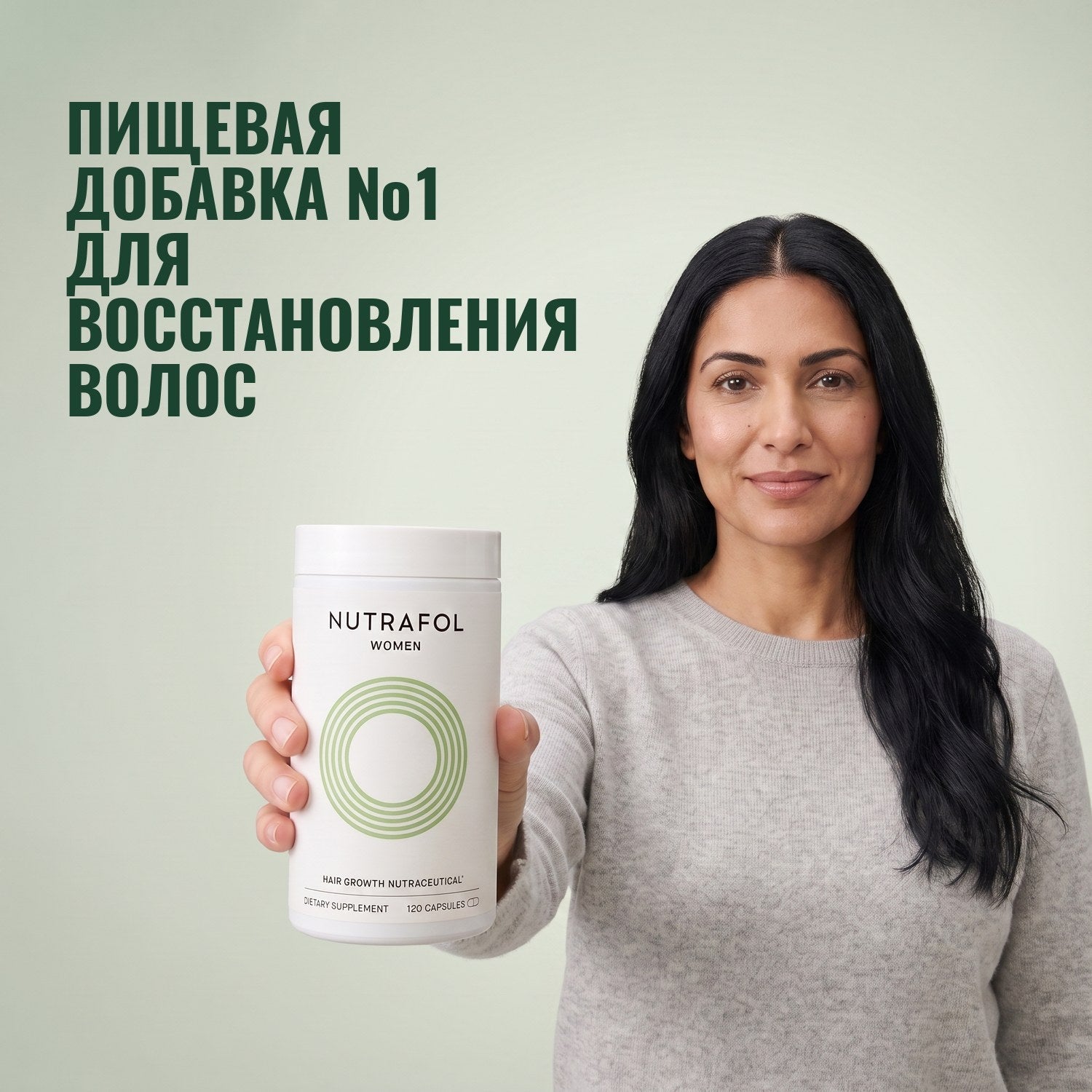 Woman holding the Nutrafol for Women 18-44 supplement box against a green background