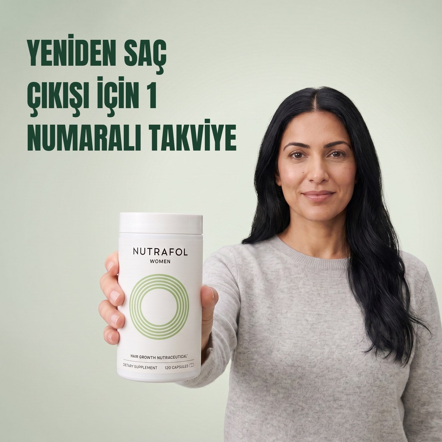 Woman holding the Nutrafol for Women 18-44 supplement box against a green background
