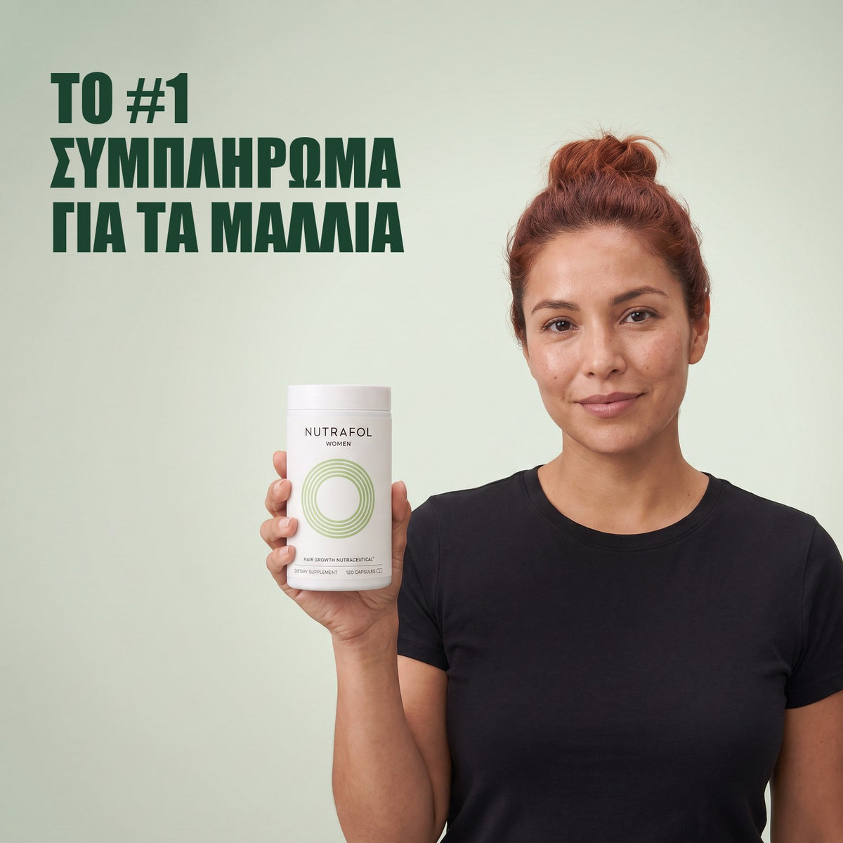 Γυναίκα κρατά το κουτί συμπληρώματος διατροφής Nutrafol for Women 18-44 σε πράσινο φόντο