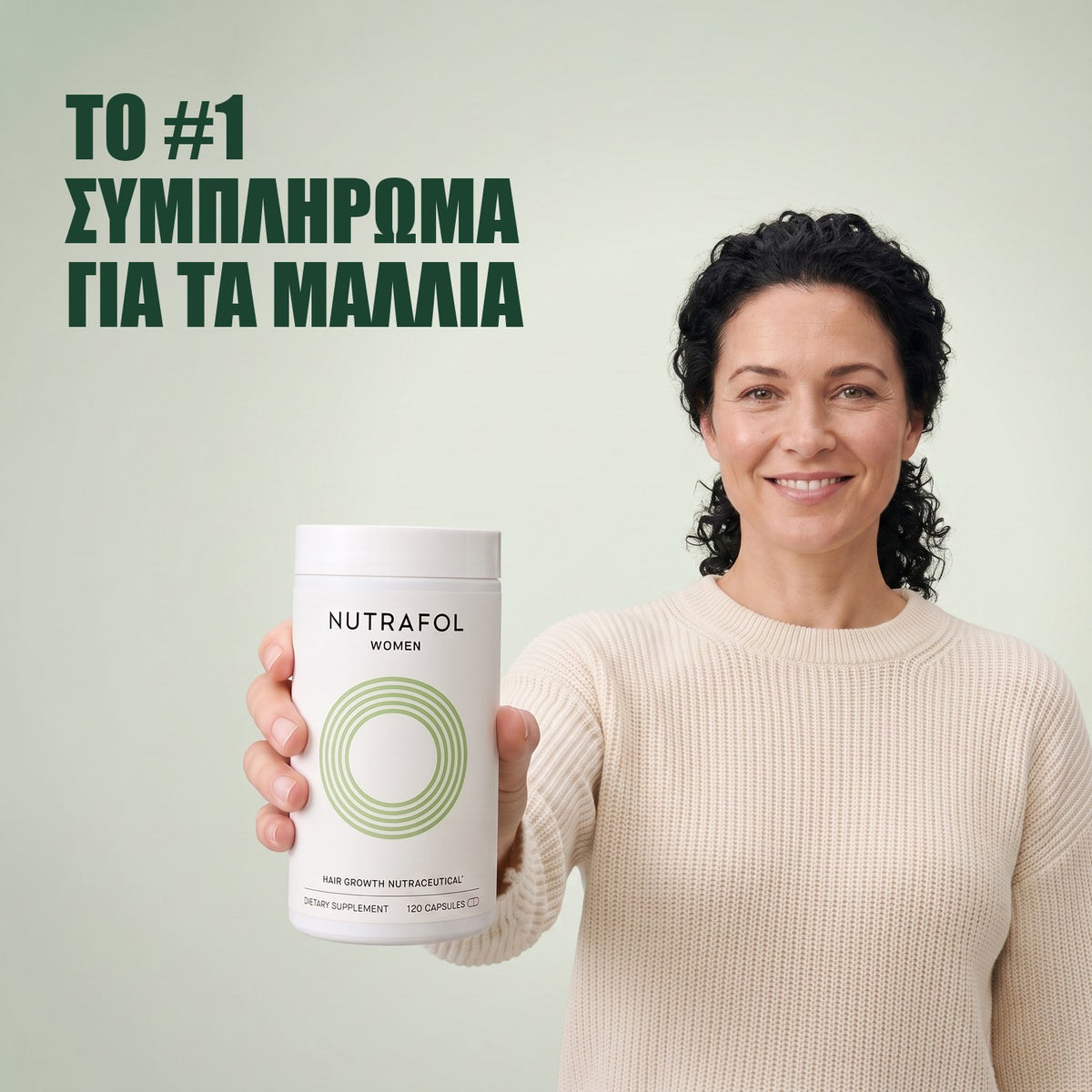 Γυναίκα κρατά το κουτί συμπληρώματος διατροφής Nutrafol for Women 18-44 σε πράσινο φόντο