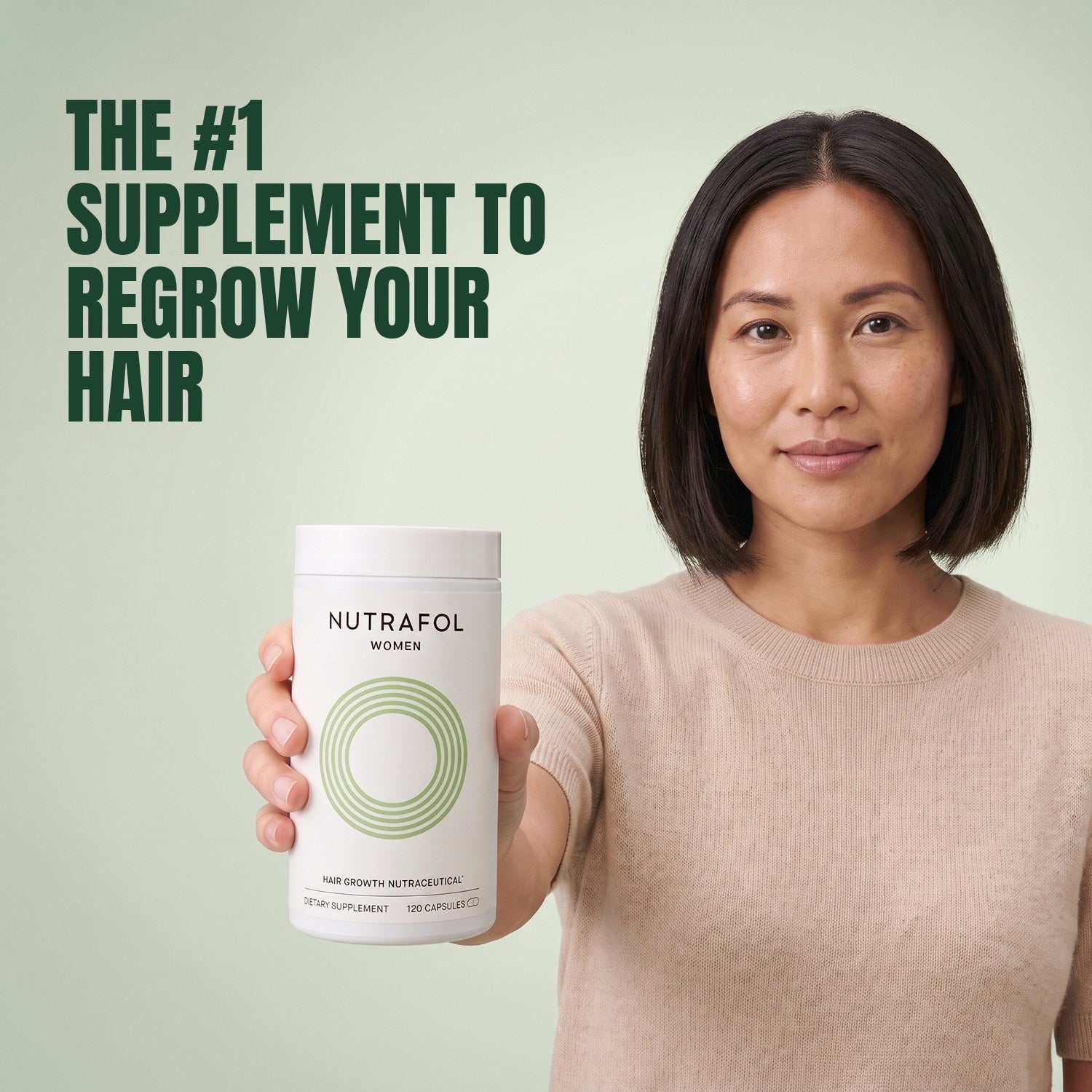 Woman holding the Nutrafol for Women 18-44 supplement box against a green background