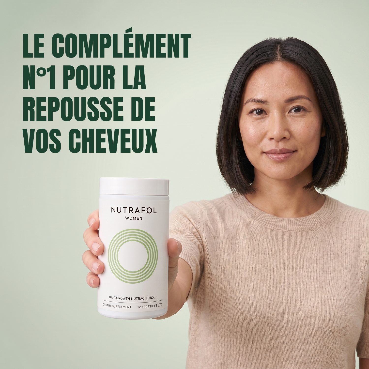 Woman holding the Nutrafol for Women 18-44 supplement box against a green background