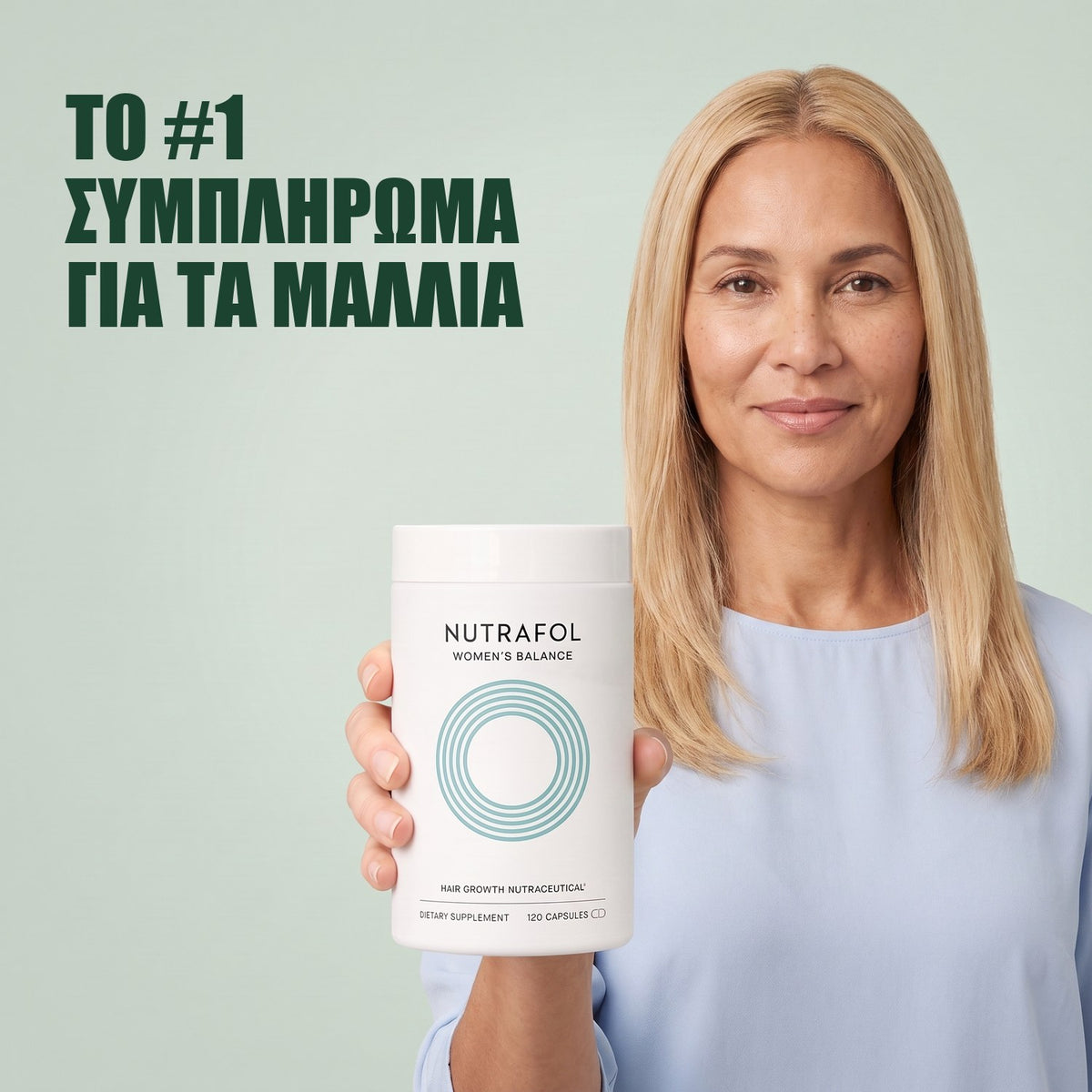 Γυναίκα κρατά το κουτί συμπληρώματος διατροφής Nutrafol for Women 45+ σε πράσινο φόντο