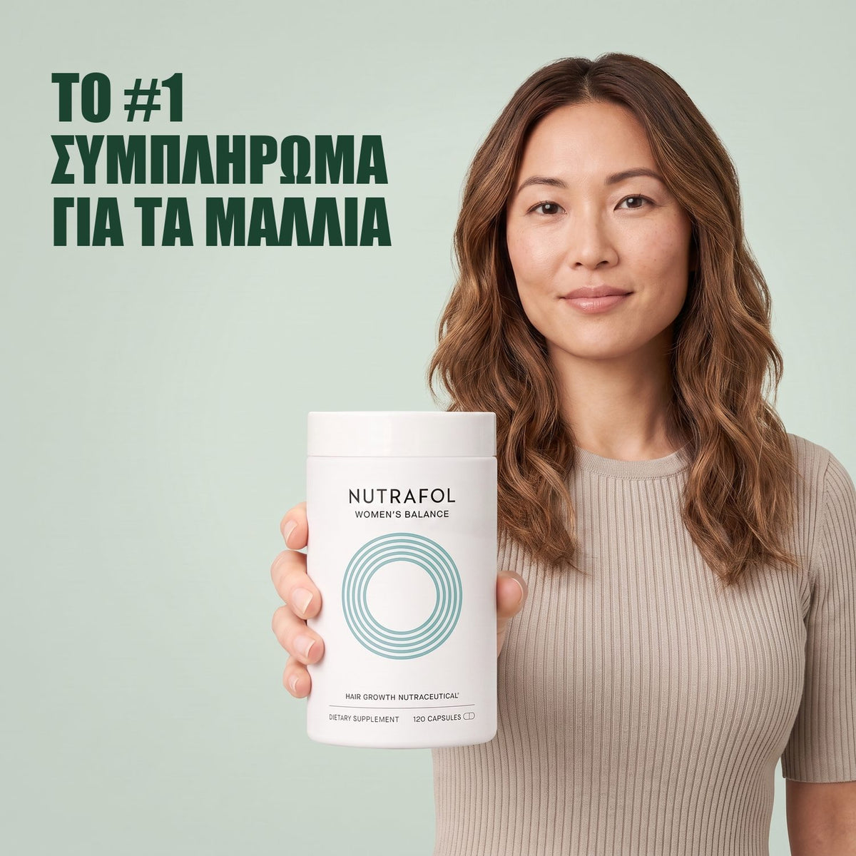 Γυναίκα κρατά το κουτί συμπληρώματος διατροφής Nutrafol for Women 45+ σε πράσινο φόντο