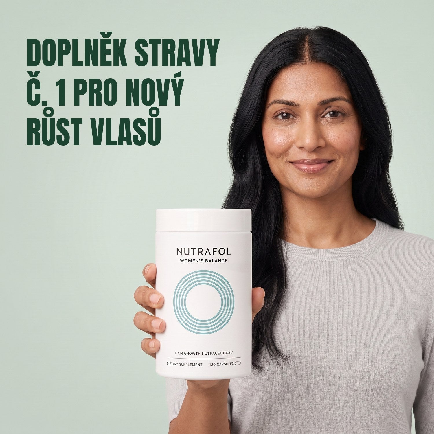 Žena drží krabičku doplňku stravy Nutrafol for Women 45+ na zeleném pozadí