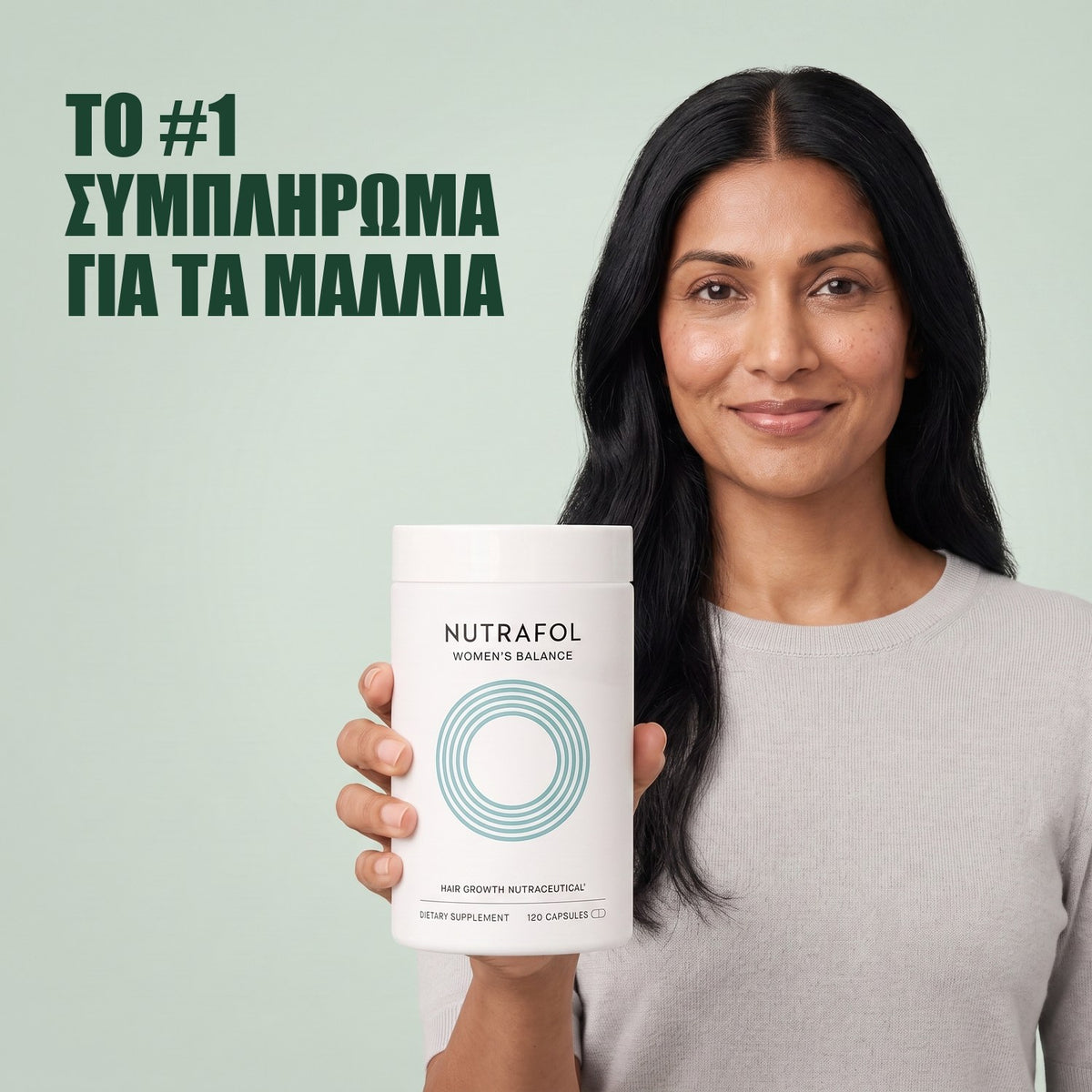 Γυναίκα κρατά το κουτί συμπληρώματος διατροφής Nutrafol for Women 45+ σε πράσινο φόντο