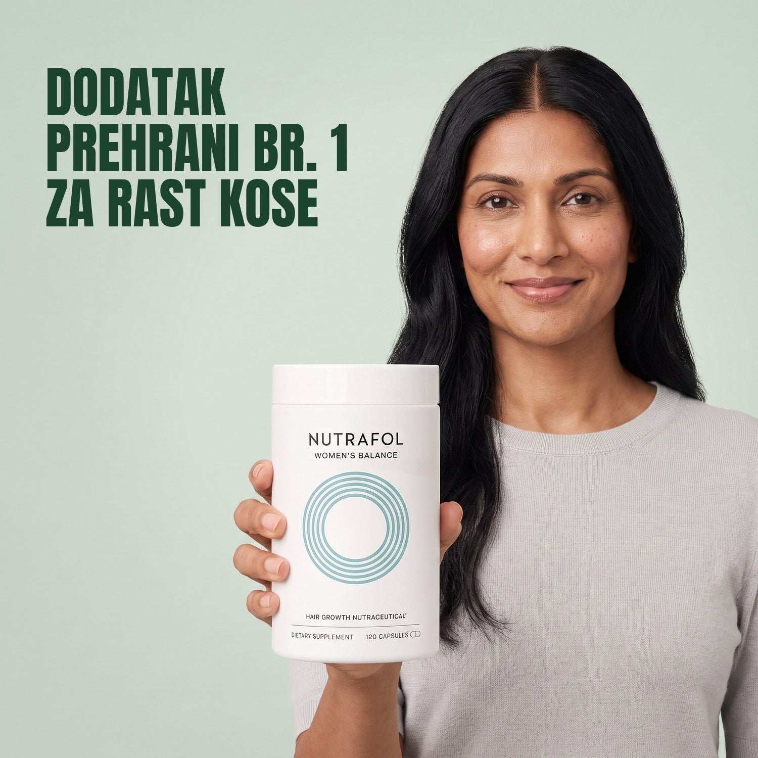 Žena drži kutiju dodatka prehrani Nutrafol for Women 45+ na zelenoj pozadini