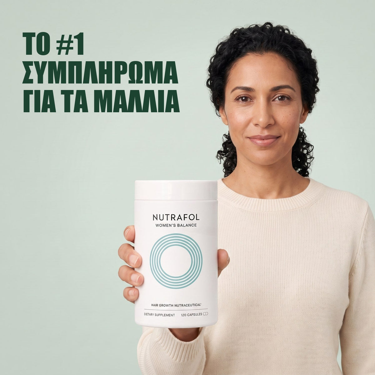 Γυναίκα κρατά το κουτί συμπληρώματος διατροφής Nutrafol for Women 45+ σε πράσινο φόντο