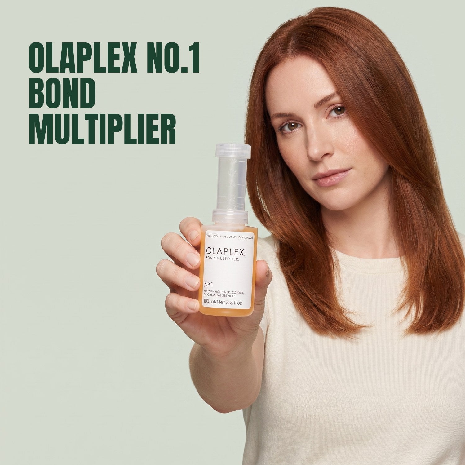 Frau hält Olaplex No.1 Bond Multiplier vor grünem Hintergrund