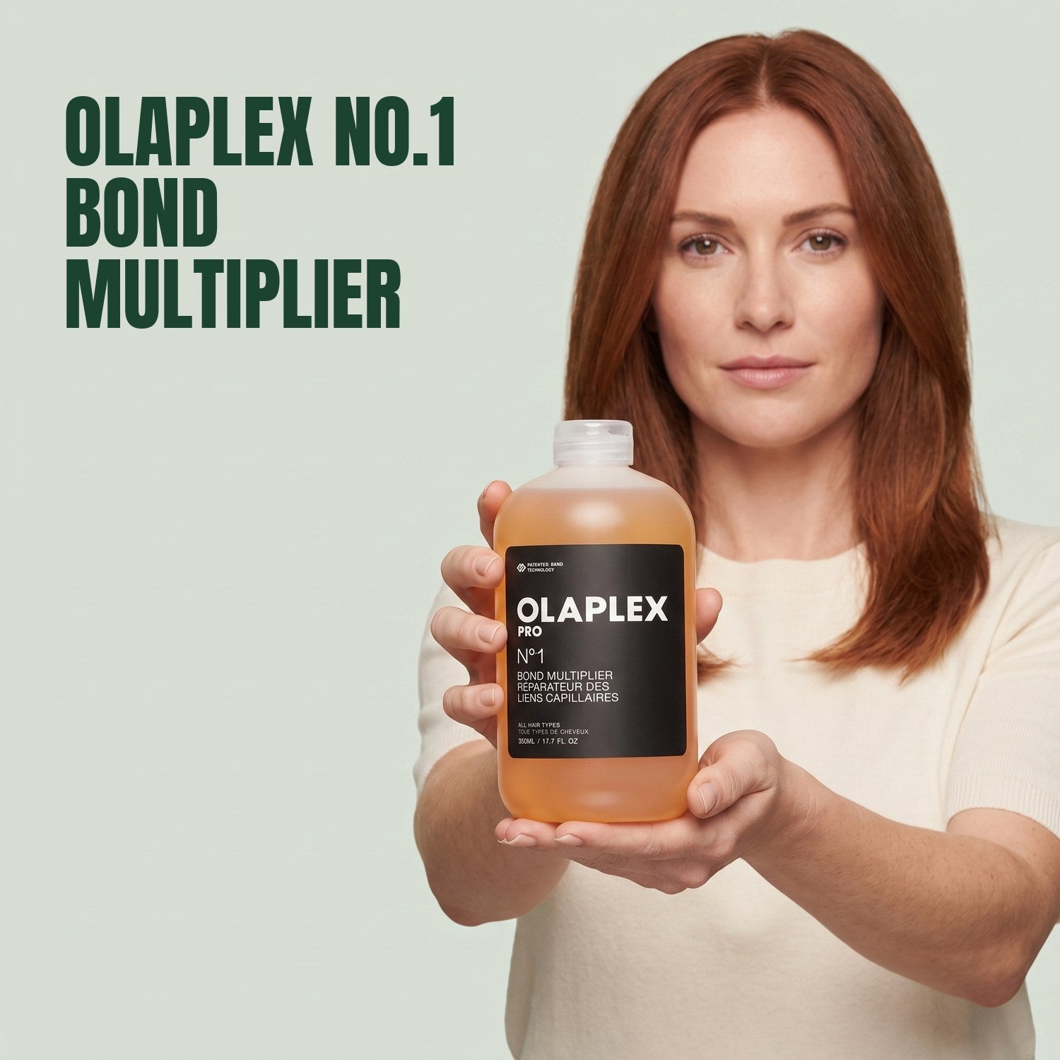 Woman holding Olaplex No.1 Bond Multiplier against a green background