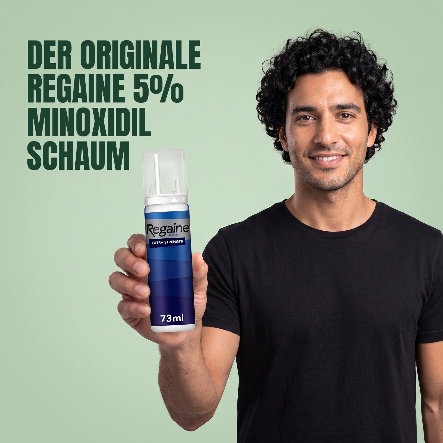 Man holding the Regaine for Men Minoxidil 5% foam pack against a green background