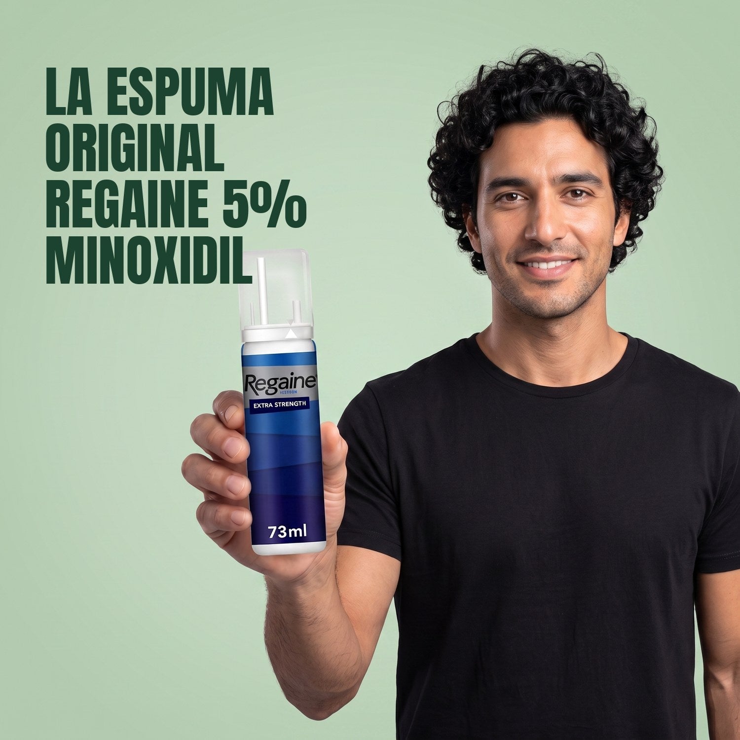 Man holding the Regaine for Men Minoxidil 5% foam pack against a green background