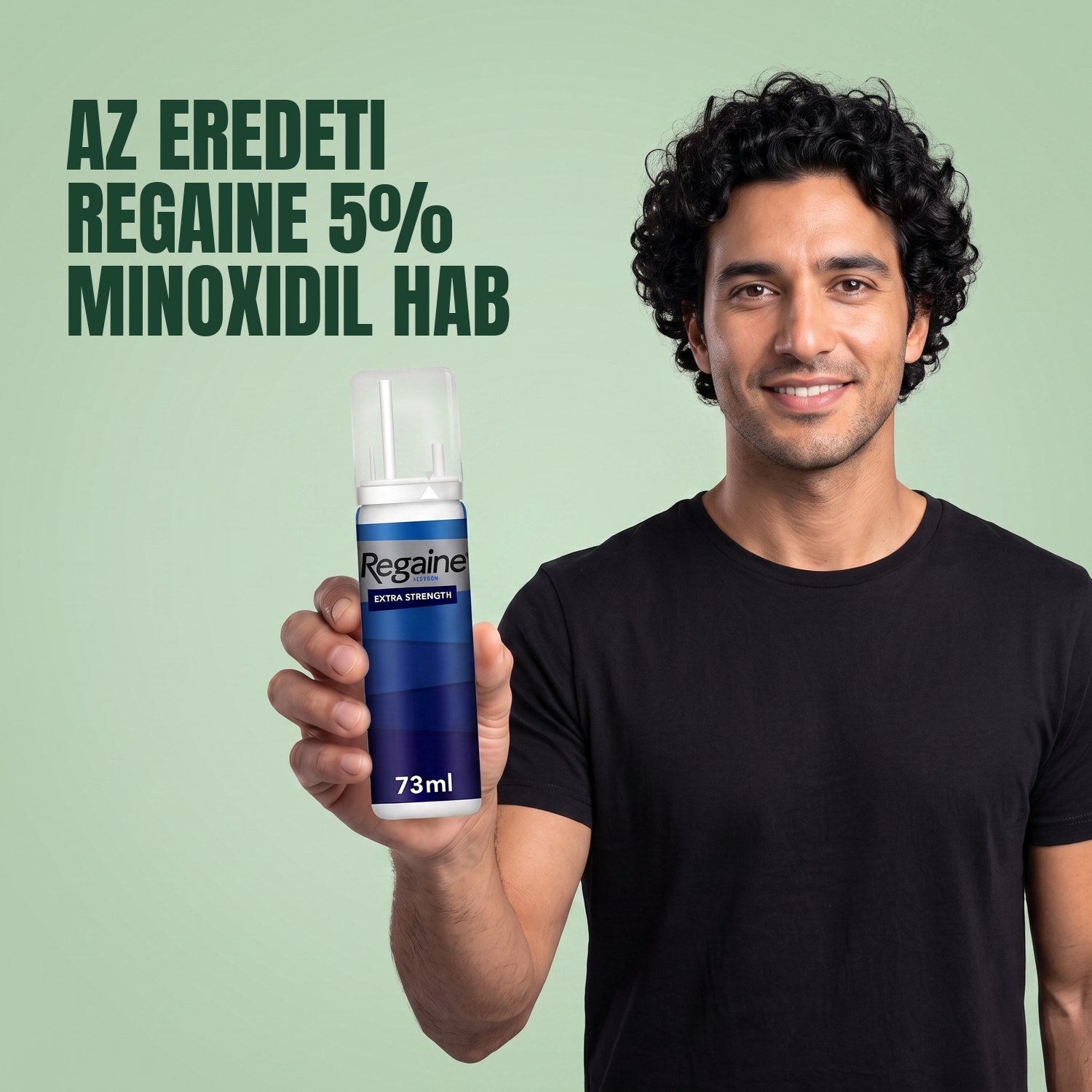 Férfi tartja a Regaine for Men Minoxidil 5% hab csomagját, zöld háttér előtt
